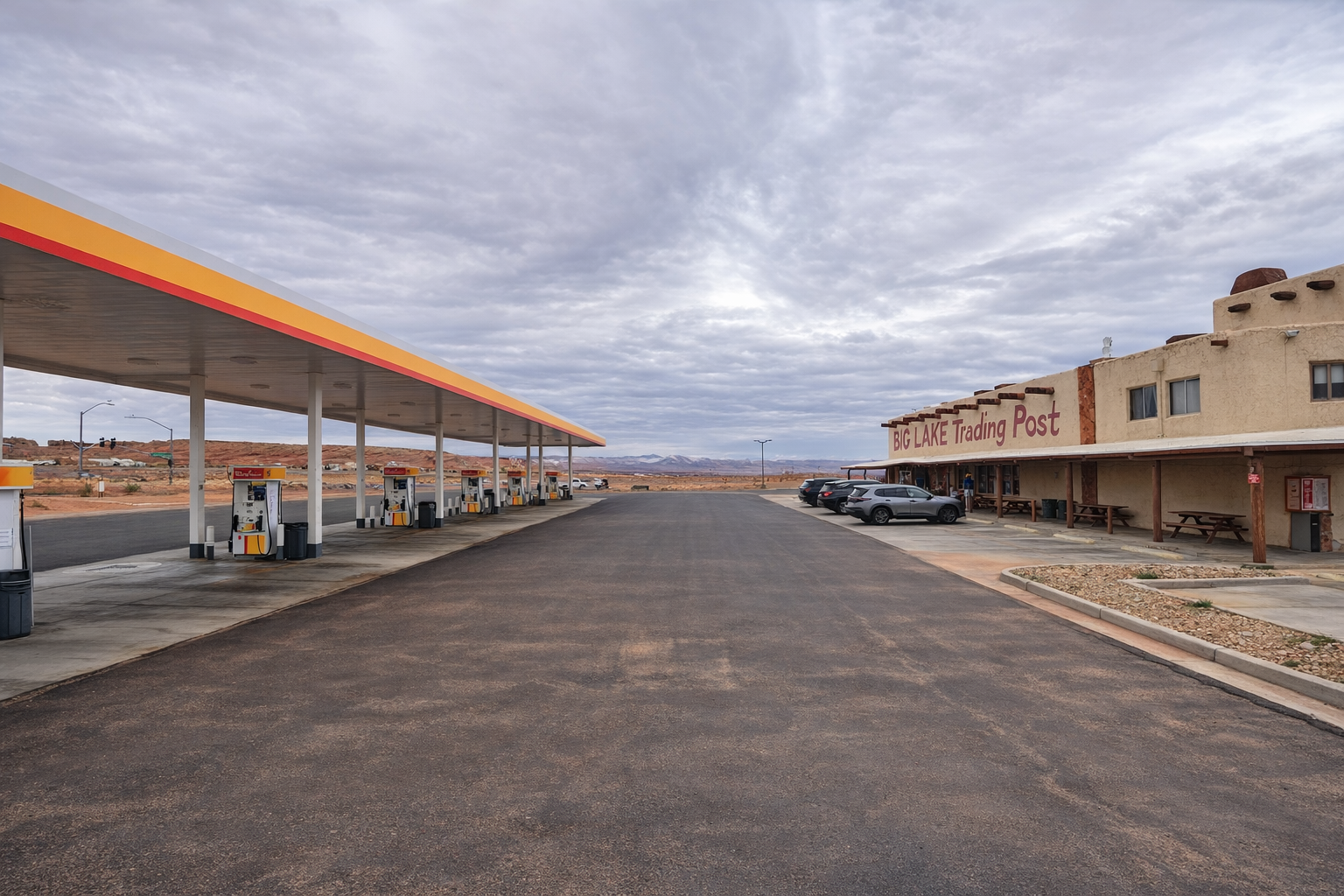 Wide view of Shell gas station at 1501 Coppermine Road in Page Arizona with fuel pumps and the Big Lake Trading Post under a dramatic desert sky
