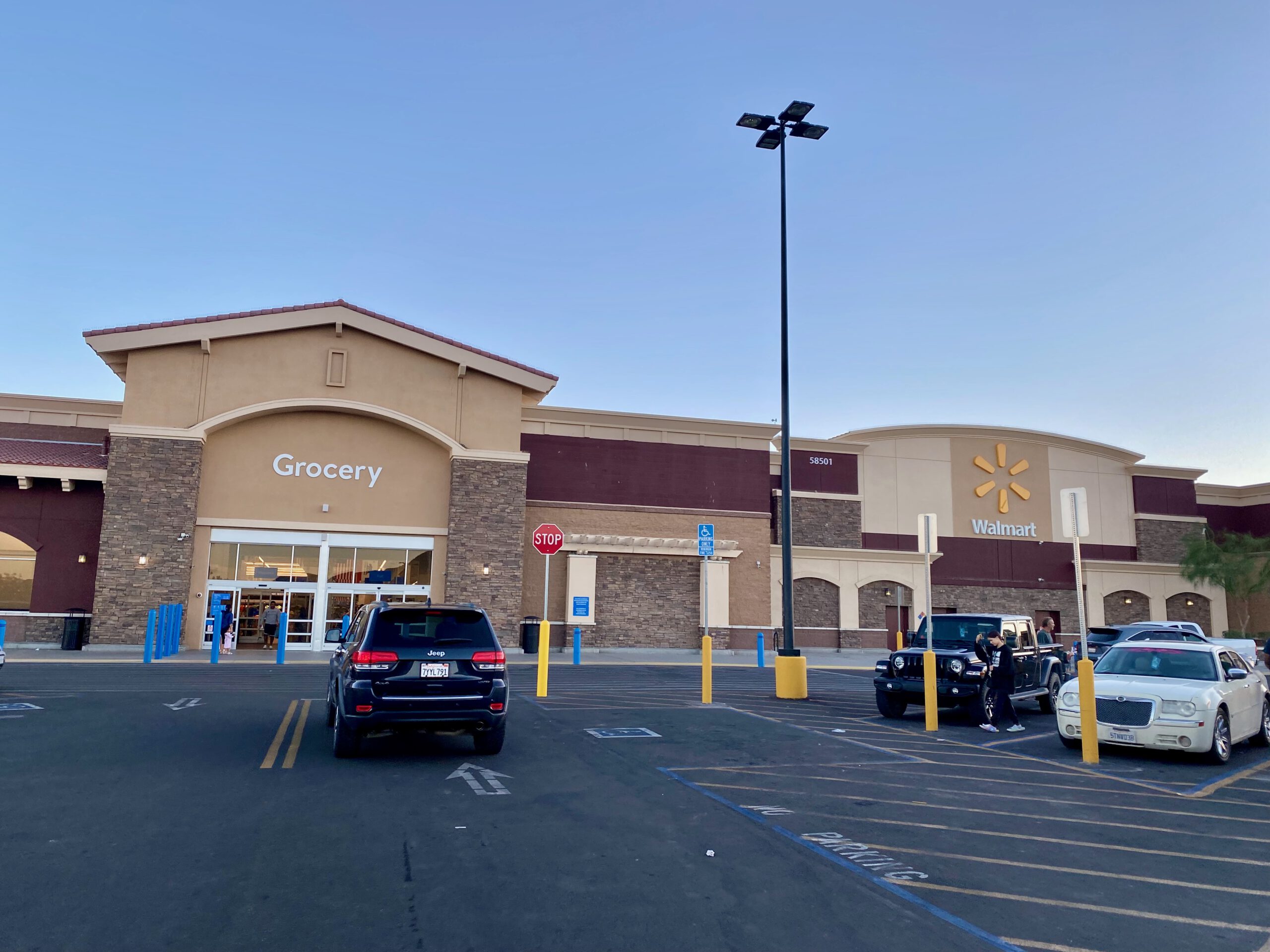 Exterior view of Walmart Yucca Valley at dusk, showing the grocery entrance, wide parking lot, and desert evening sky near Joshua Tree National Park.