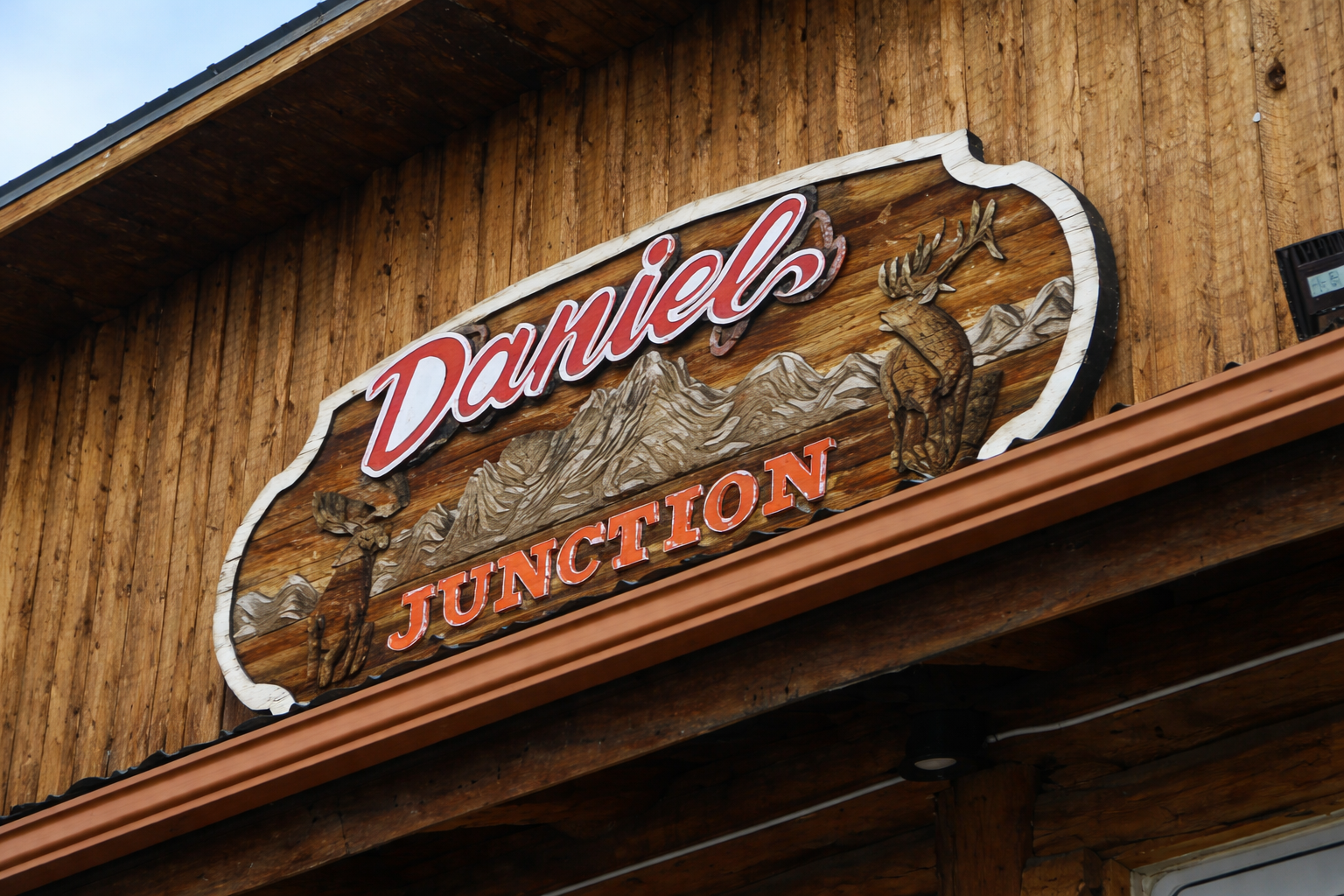 Daniel Junction Wyoming wooden entrance sign with carved mountains and elk, located along Highway 189, 191 in rural Wyoming