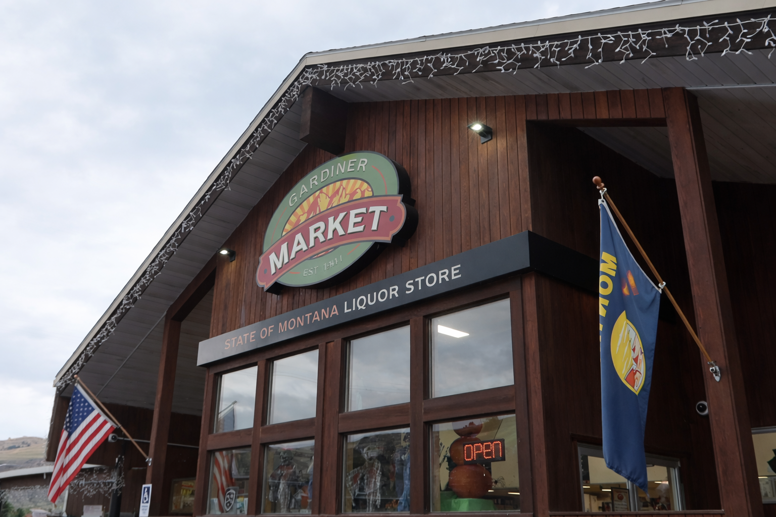 Exterior of Gardiner Market in Gardiner Montana, a local grocery store near Yellowstone National Park with American and Montana flags displayed