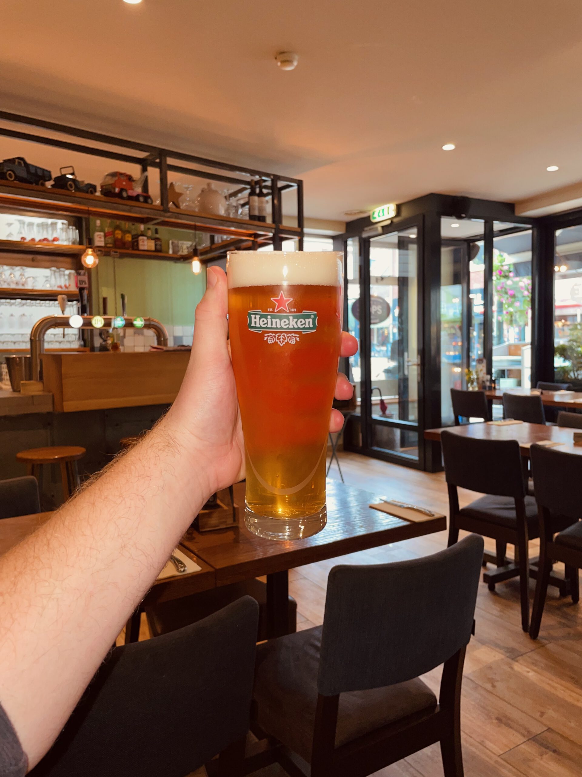 Heineken draft beer inside POPS Wassenaar, warm American diner interior with bar and seating