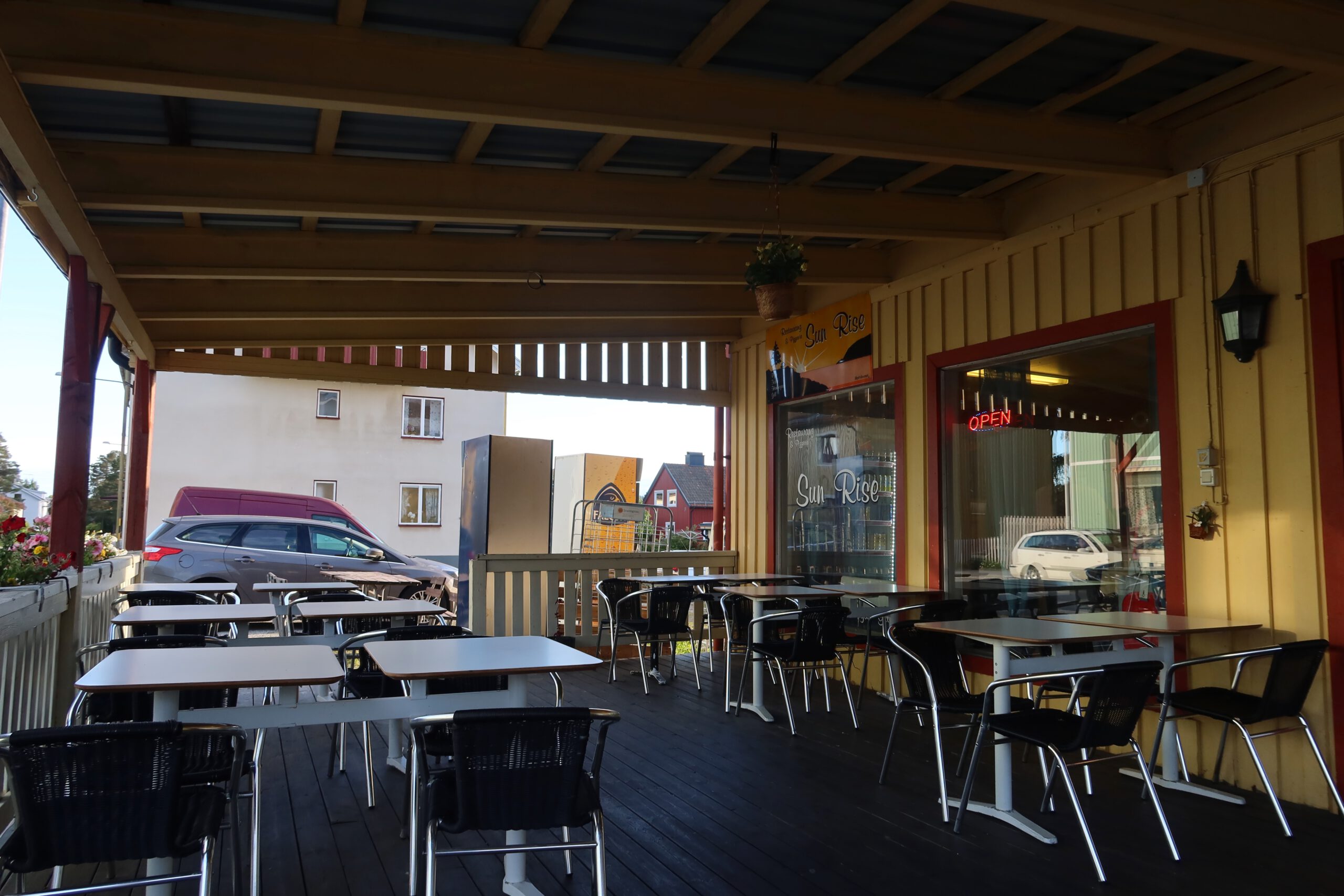 Sun Rise Nordmaling covered outdoor terrace with tables and chairs, a quiet roadside pizzeria stop in northern Sweden during a Scandinavian road trip