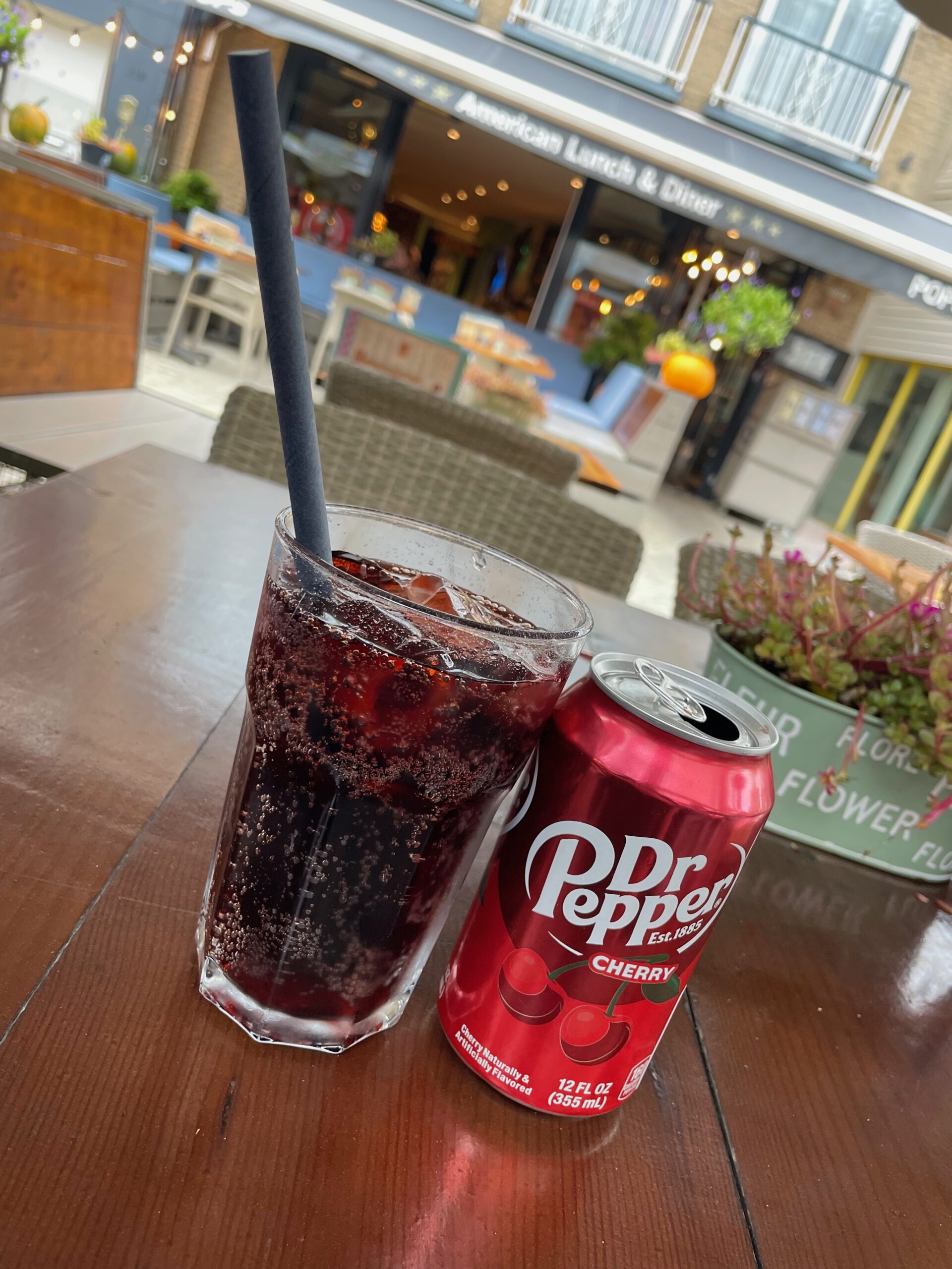 POPS Wassenaar terrace drink, Dr Pepper Cherry served in a glass and can on an outdoor table at POPS Wassenaar American diner on the Langstraat
