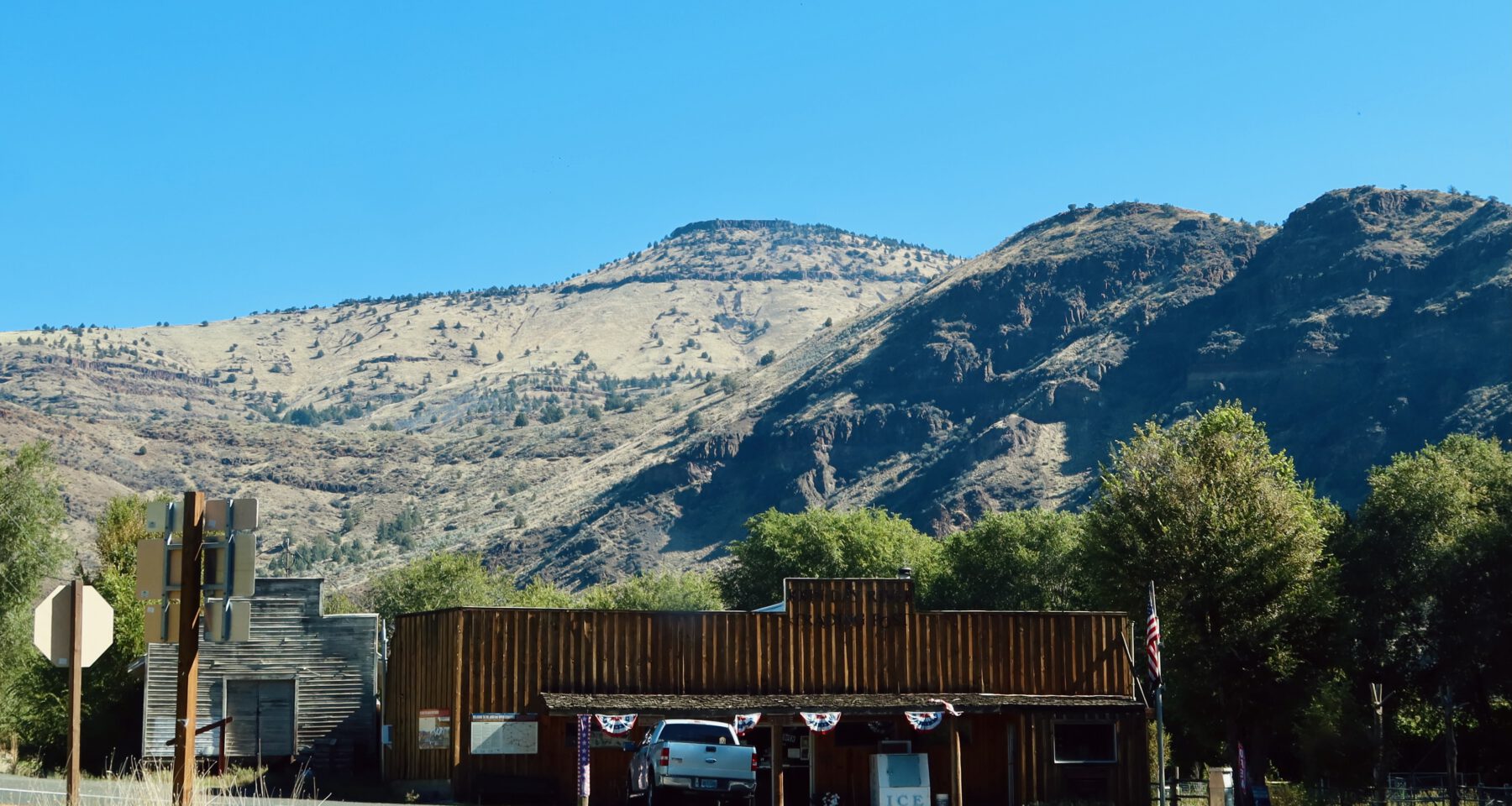 Gas stations in America, John Day River Trading Post in Kimberly Oregon with ice bucket, pickup truck, and dry mountain landscape