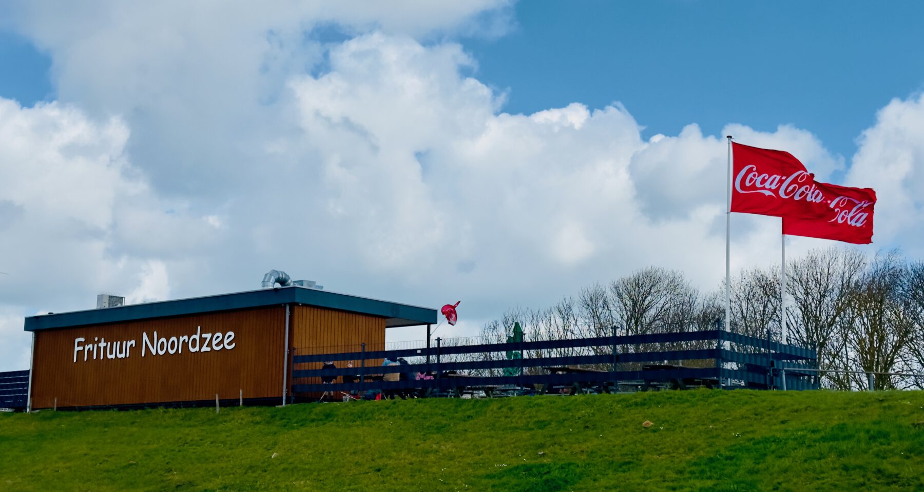 Frituur Noordzee Kamperland exterior with Coca Cola flags in Zeeland