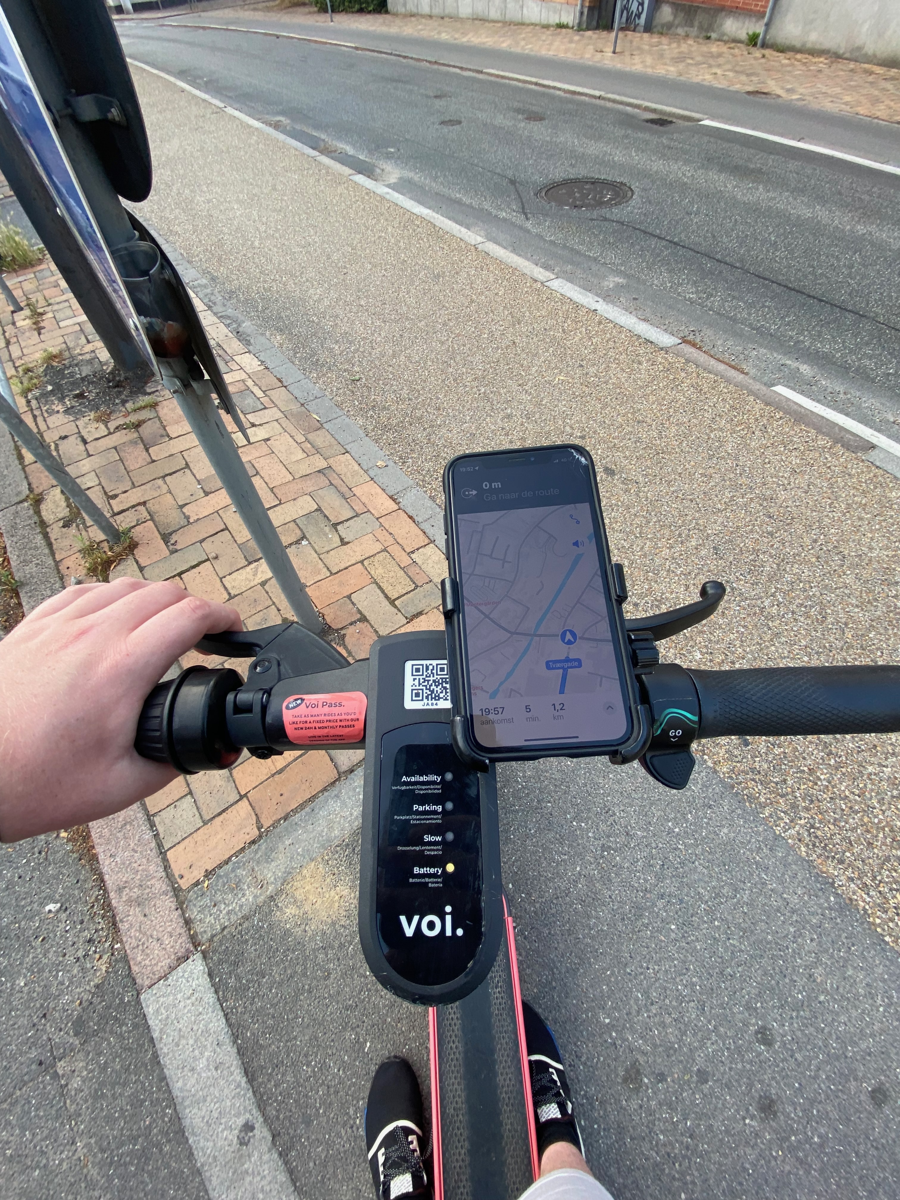 Voi Scooters Odense handlebar view with phone navigation and Voi app display during an electric scooter ride through Odense Denmark