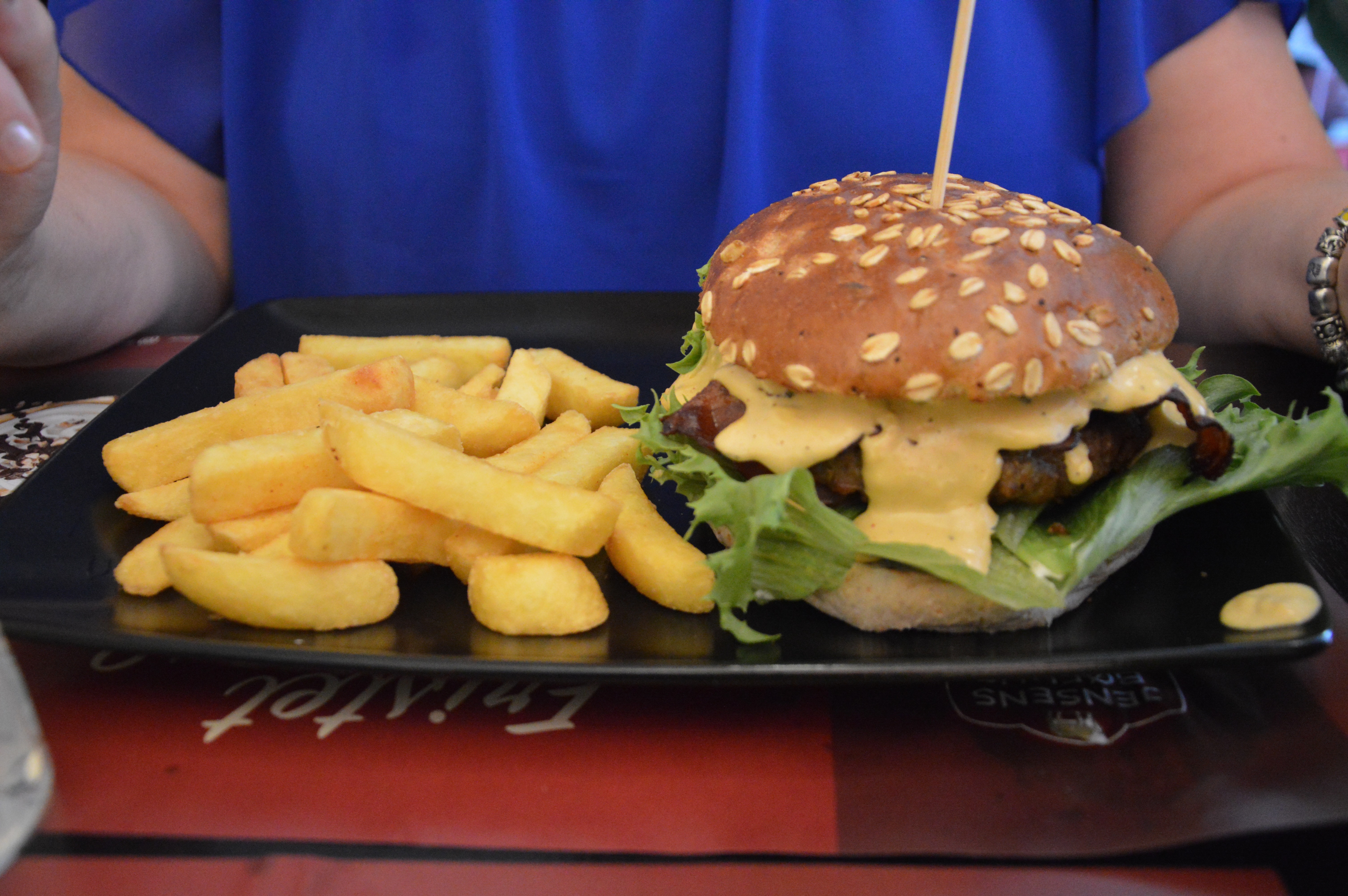 Jensens Bofhus Sonderborg review showing a burger with melted sauce lettuce and thick fries served inside the former Jensens Bøfhus restaurant in Sønderborg Denmark