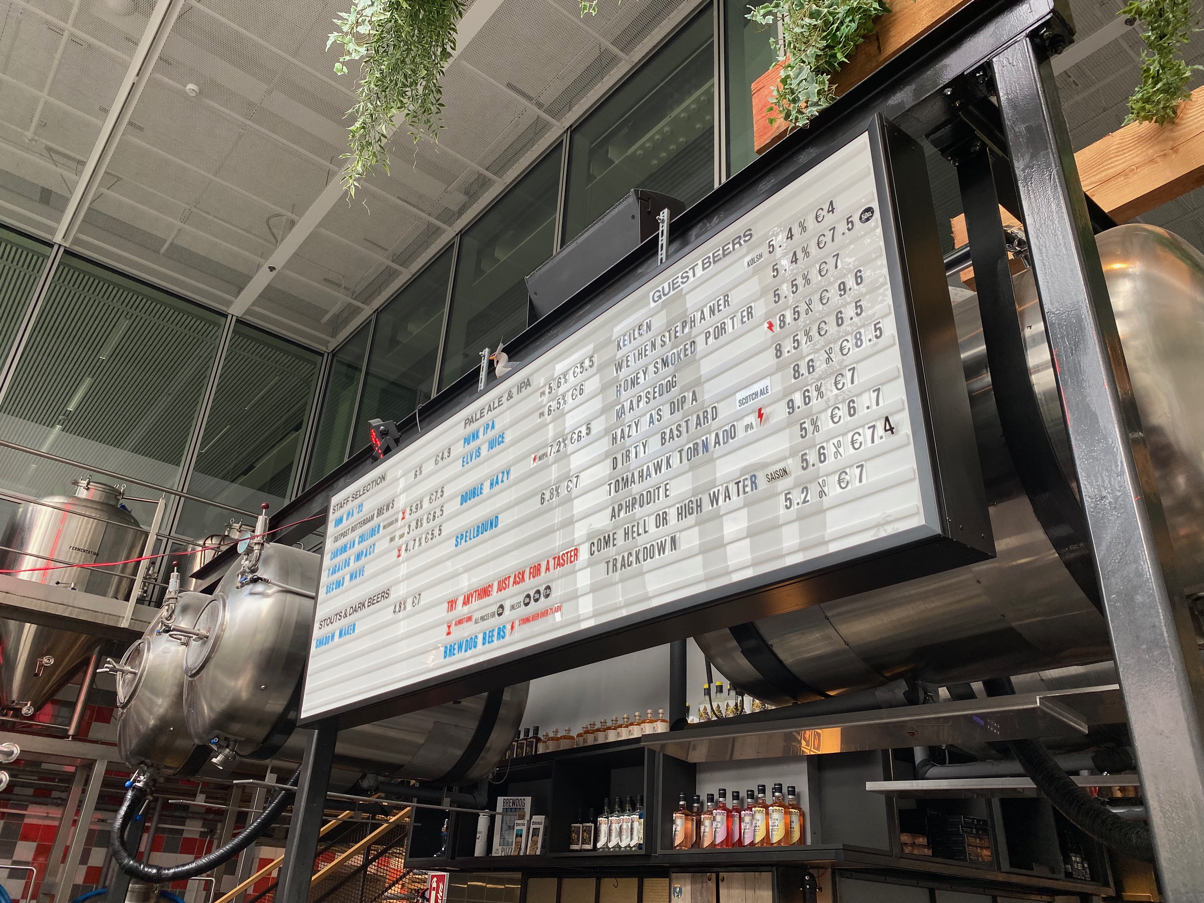 BrewDog Outpost Rotterdam Review with the BrewDog beer menu board guest beers brewery tanks taps bottles and industrial brewpub interior at Halvemaanpassage
