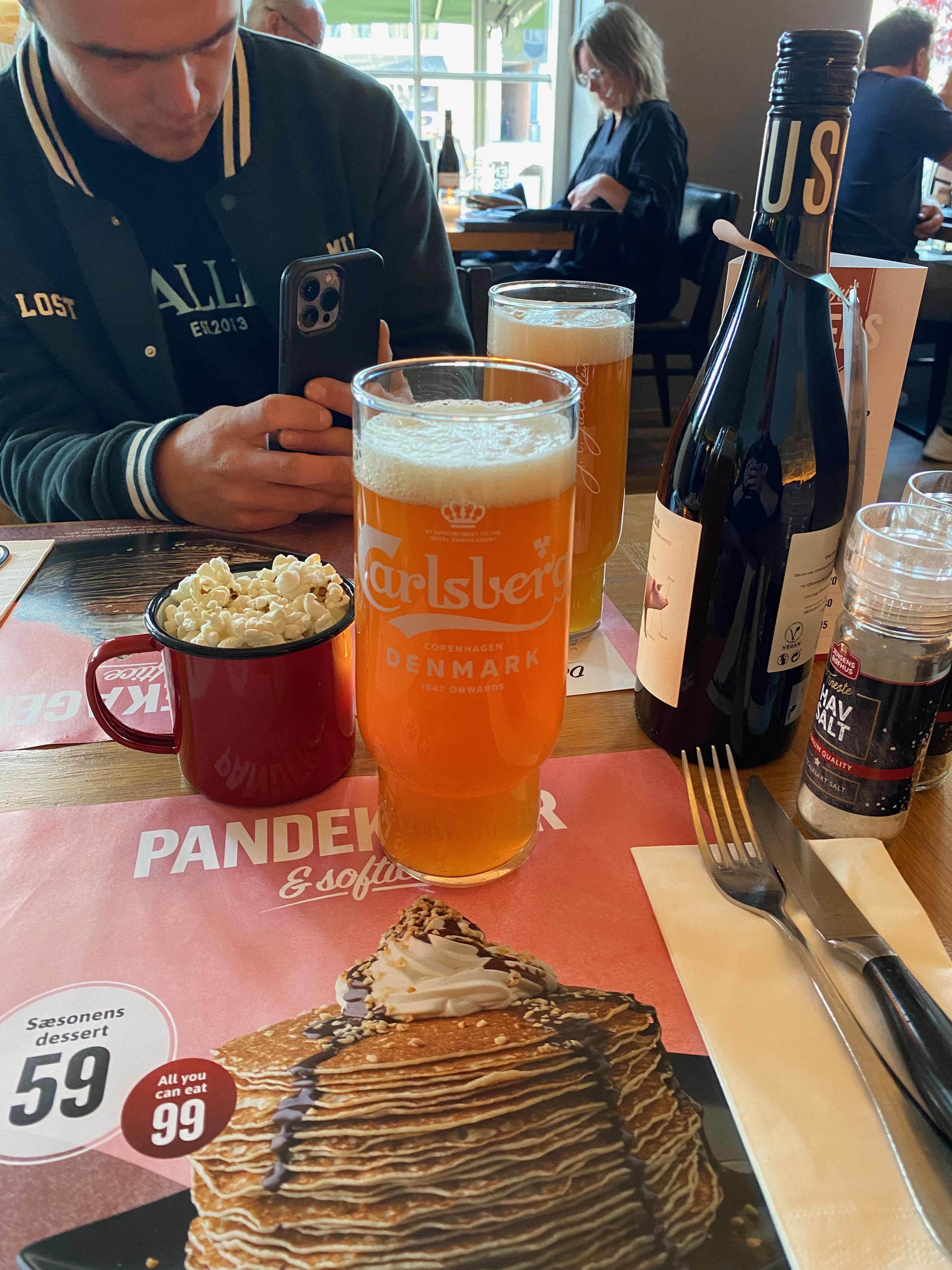 Jensens Bofhus Silkeborg review showing two cold Carlsberg draft beers a red cup of popcorn and a table setting inside the former restaurant in Silkeborg Denmark