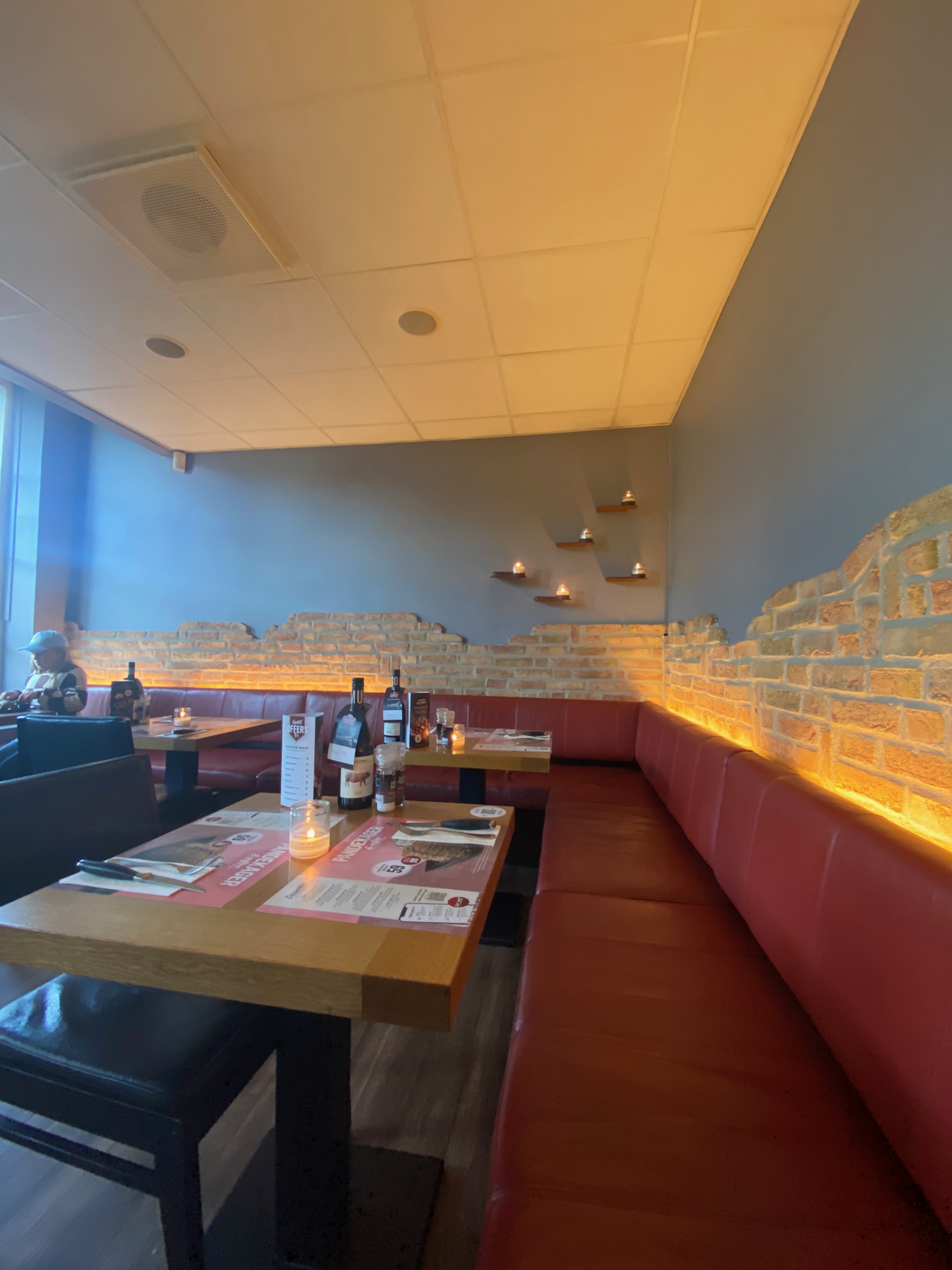 Jensens Bofhus Silkeborg review showing the warm interior of the former restaurant in Silkeborg Denmark with red booth seating brick style walls candlelit tables and cozy steakhouse atmosphere