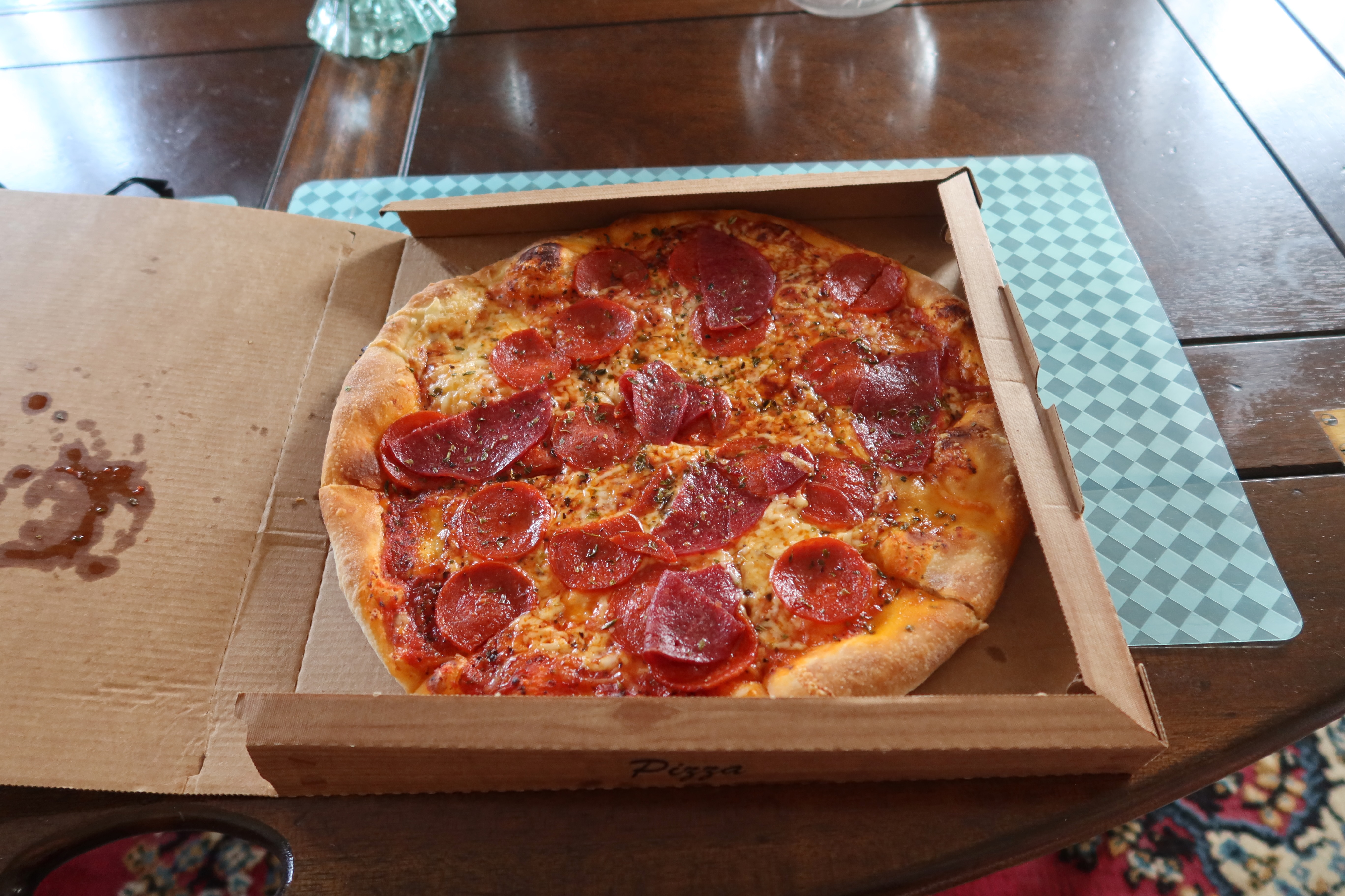 Kollund Rooms Review photo showing a pepperoni pizza in a cardboard takeaway box from the nearby pizzeria in Kruså, eaten during a stay at Kollund Rooms in Denmark.