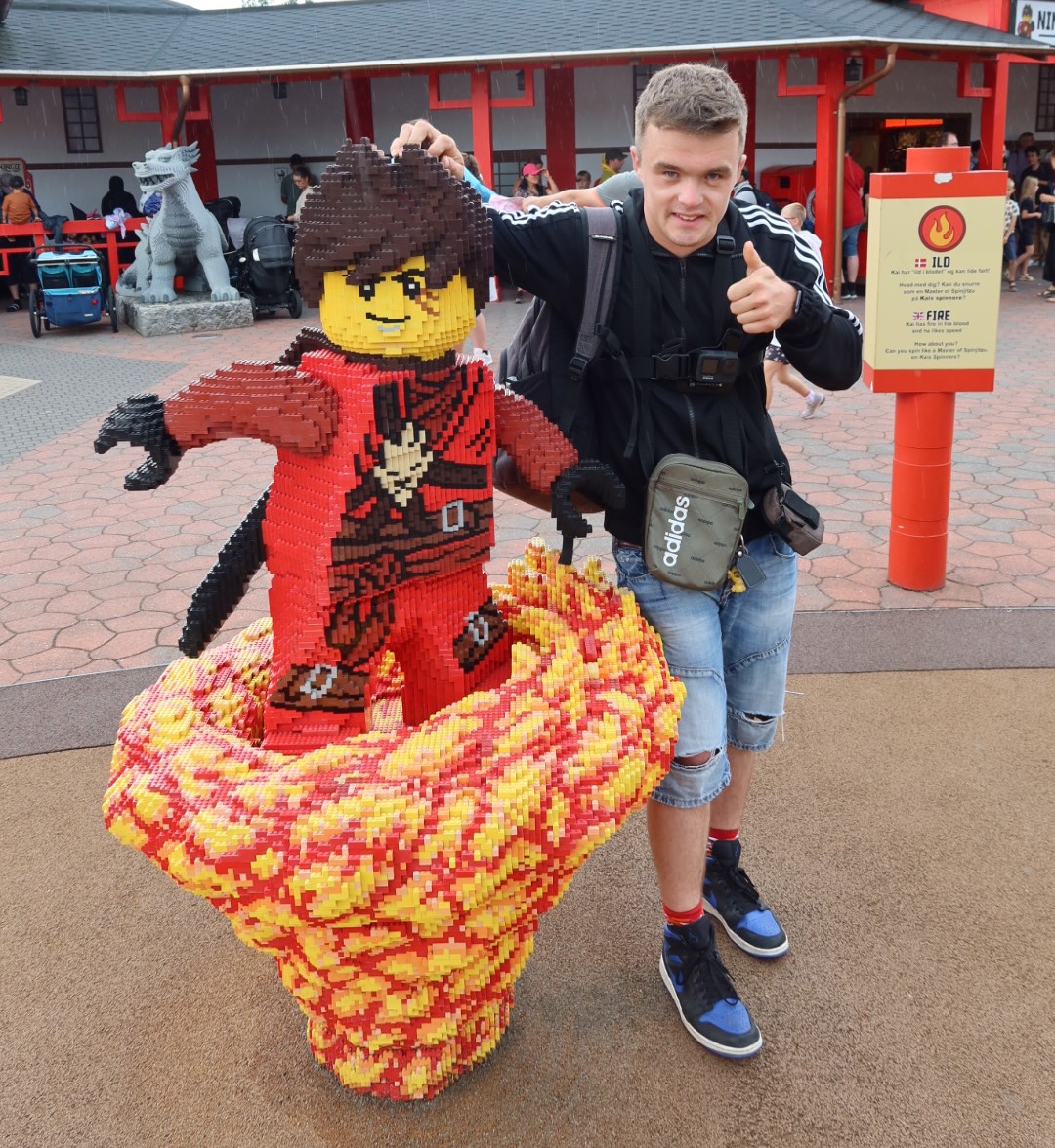 LEGOLAND Billund review IMG 2781 showing a visitor posing with a large red NINJAGO LEGO figure near NINJAGO The Ride at LEGOLAND Billund Denmark