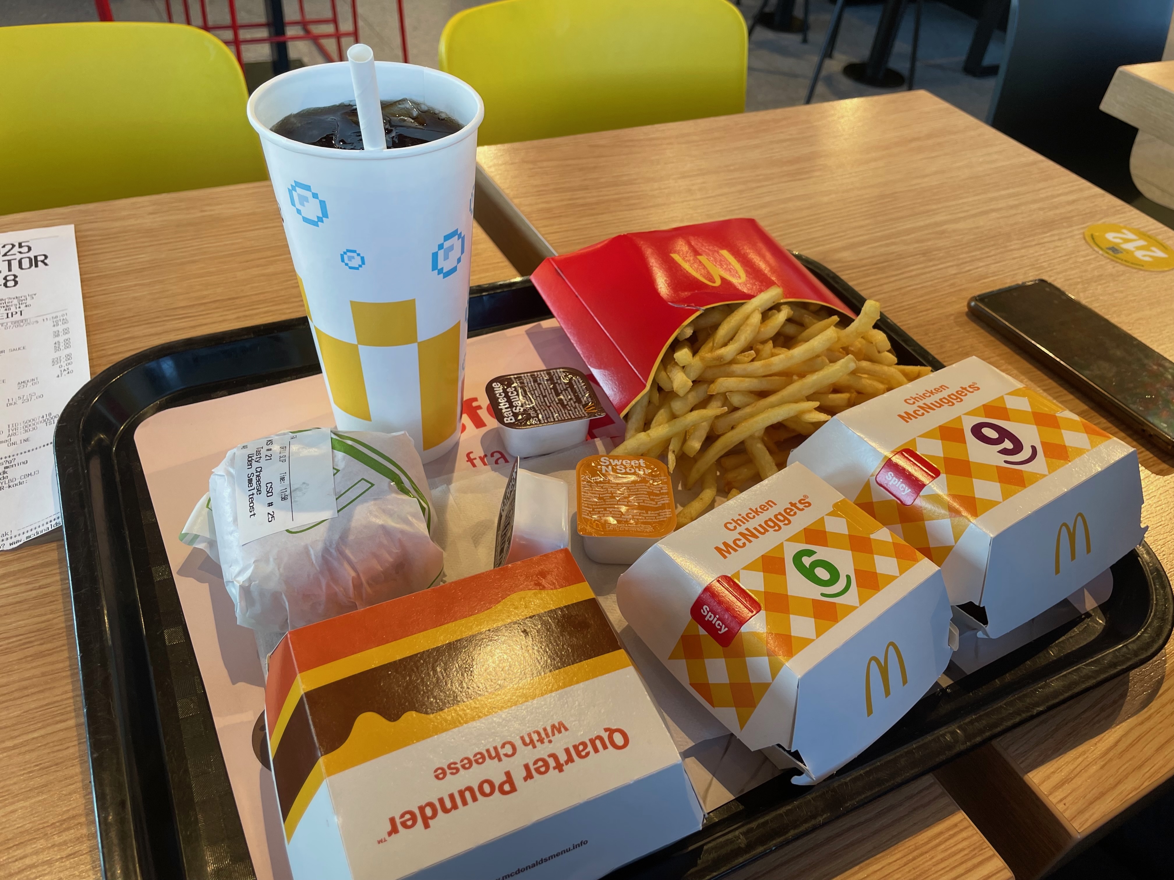 McDonald's Brønderslev meal with Quarter Pounder with Cheese, Chicken McNuggets, spicy McNuggets, fries, dipping sauces and a cold drink served on a tray inside the restaurant in Denmark