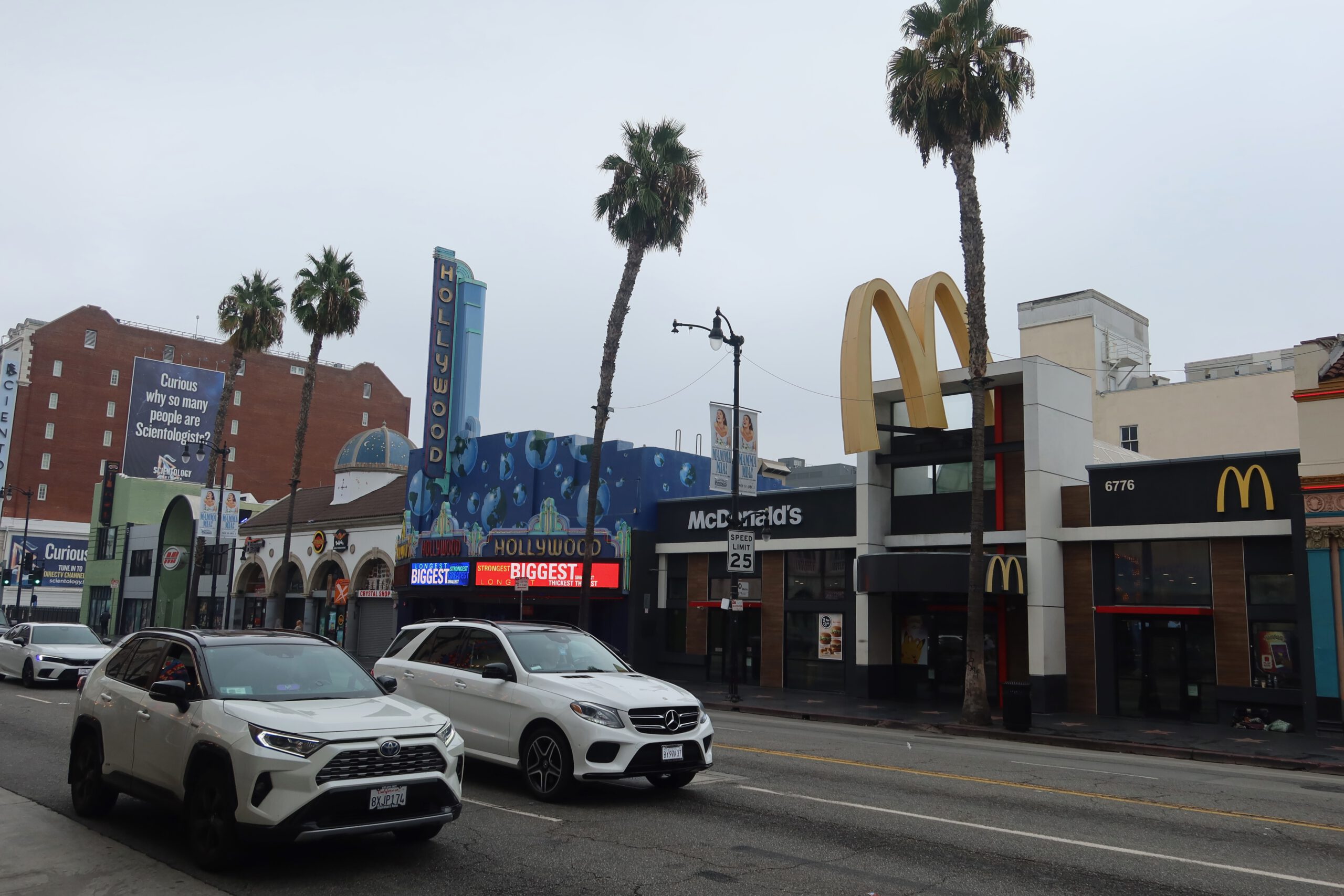 Hollywood Boulevard in Los Angeles featuring the McDonald’s restaurant, Hollywood signage, palm trees, and passing cars, capturing everyday life along this famous street.