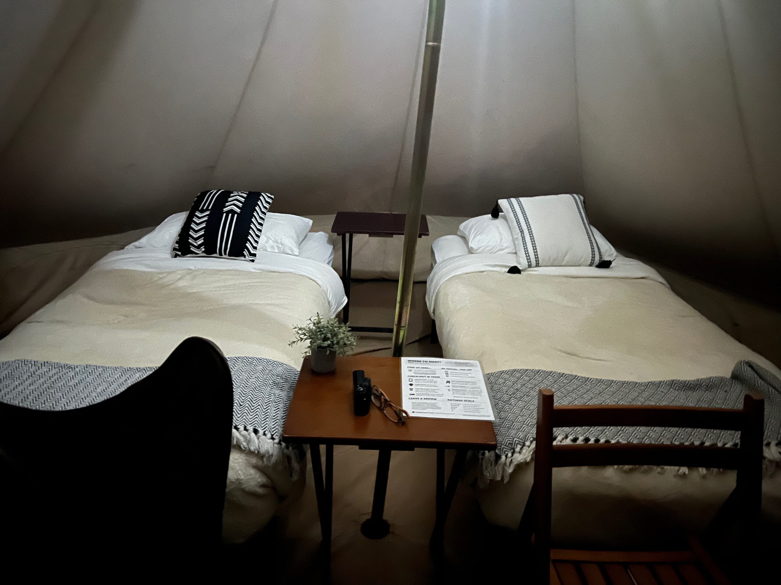 Interior of a Wander Camp Grand Canyon glamping tent with two single beds, warm blankets, and simple rustic furniture designed for off-grid comfort near the Grand Canyon