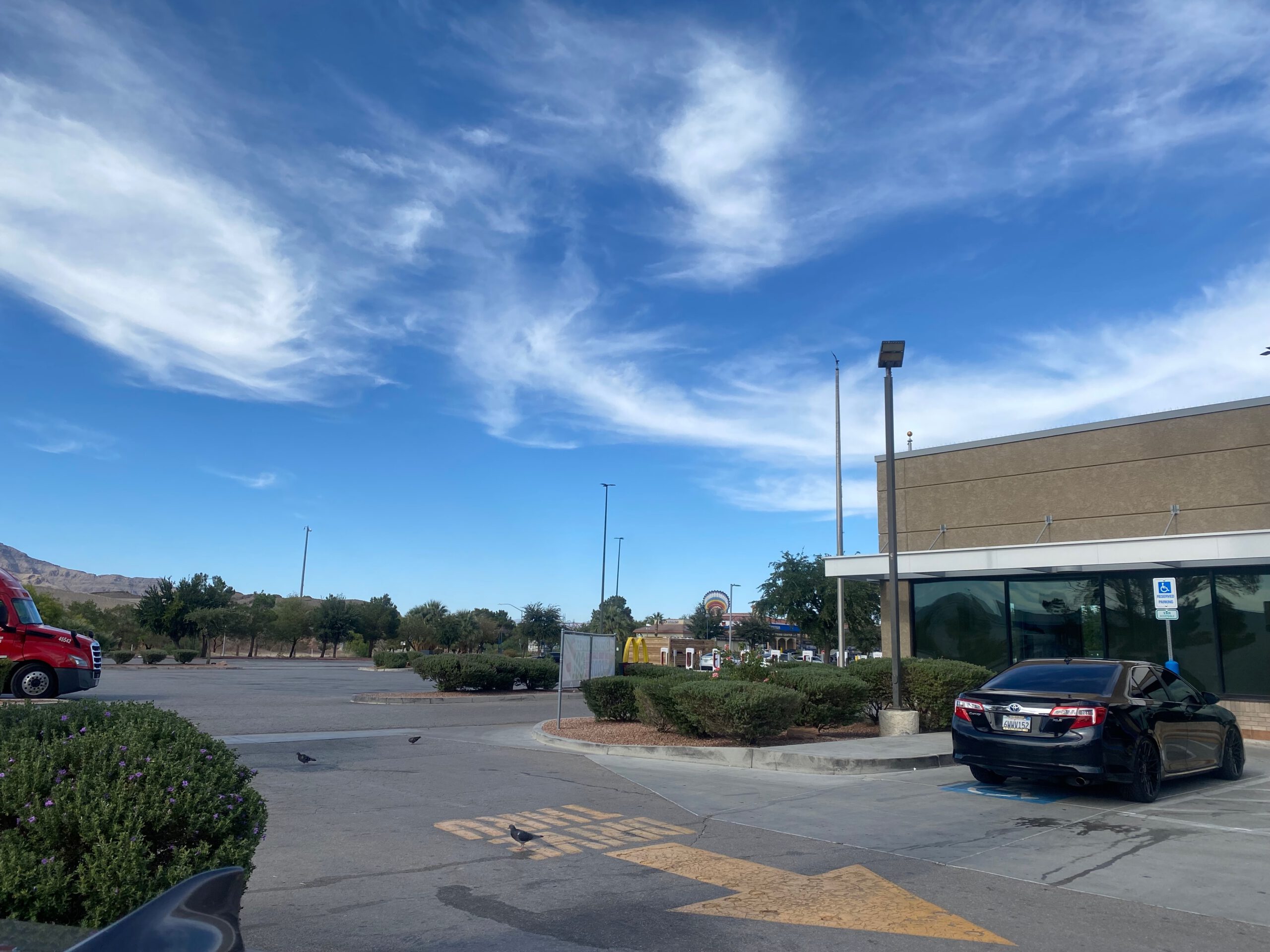 Wide exterior view of McDonalds Primm Nevada showing the building, open parking area, desert surroundings, and clear blue sky