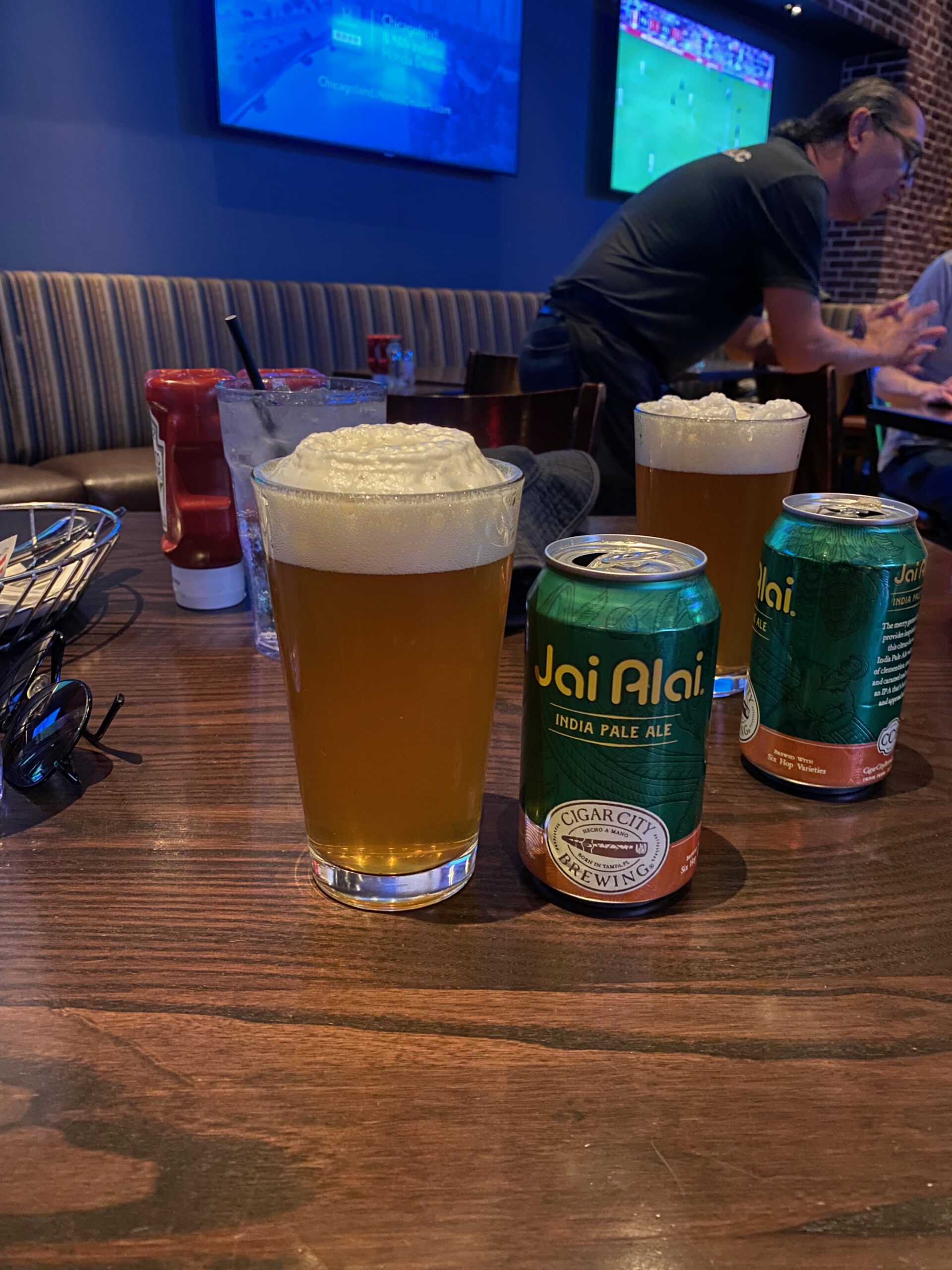 Craft beer and Jai Alai India Pale Ale on a table inside Public House sports bar at Luxor Hotel Las Vegas, with live sports on TV screens