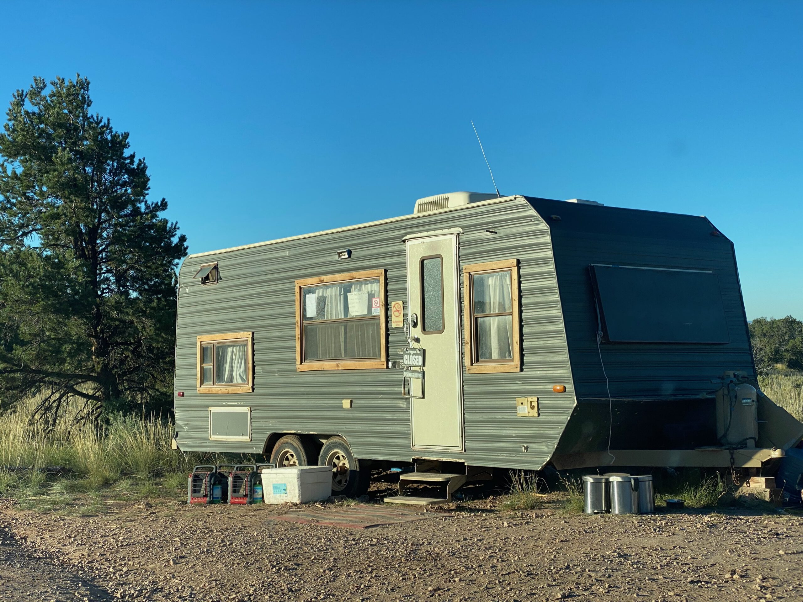 Entrance and reception trailer at Wander Camp Grand Canyon review, showing the rustic off-grid check-in area surrounded by Arizona high desert nature