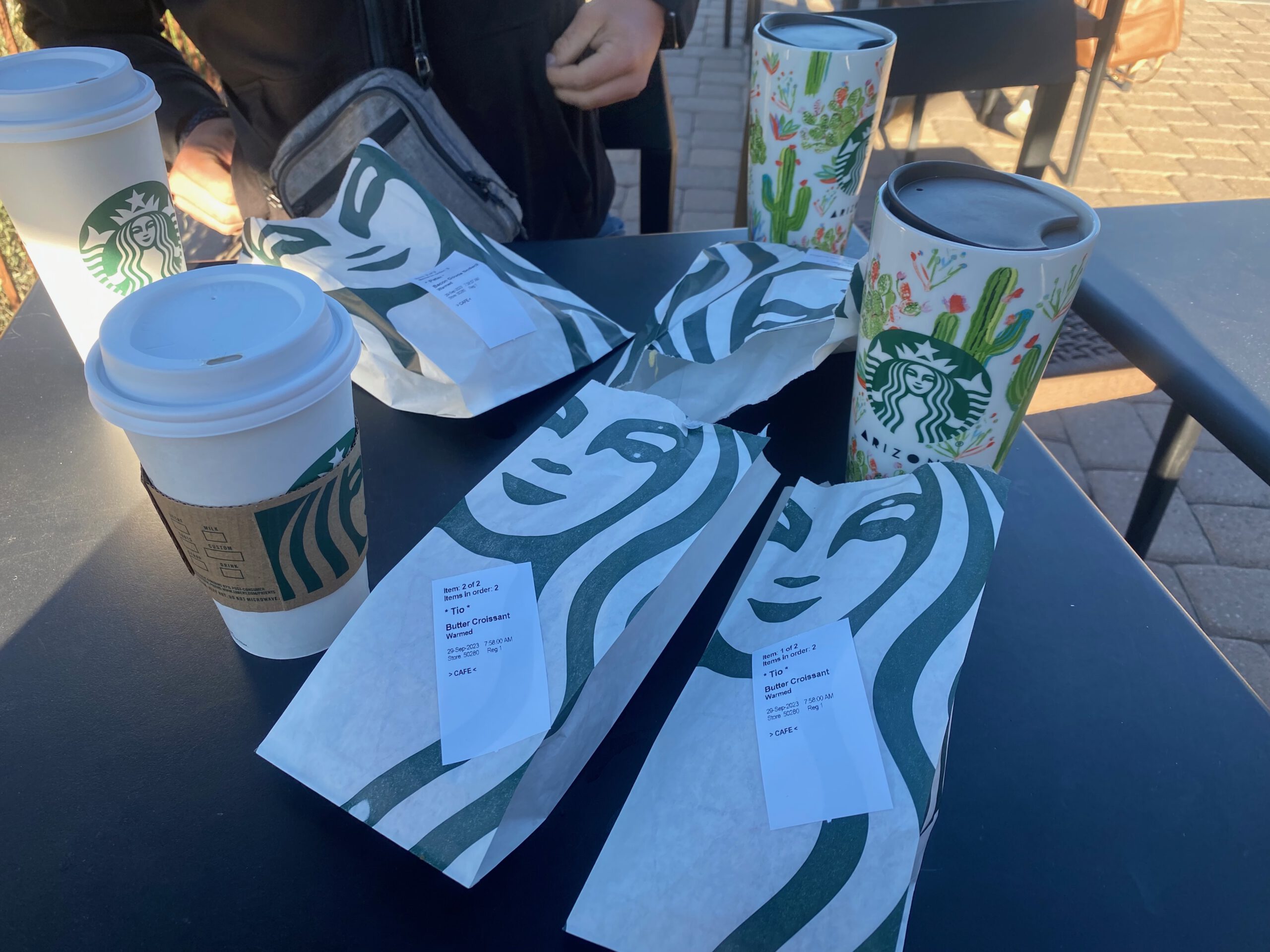 Starbucks coffee cups and breakfast pastries on an outdoor table at the Tusayan Starbucks near the Grand Canyon.