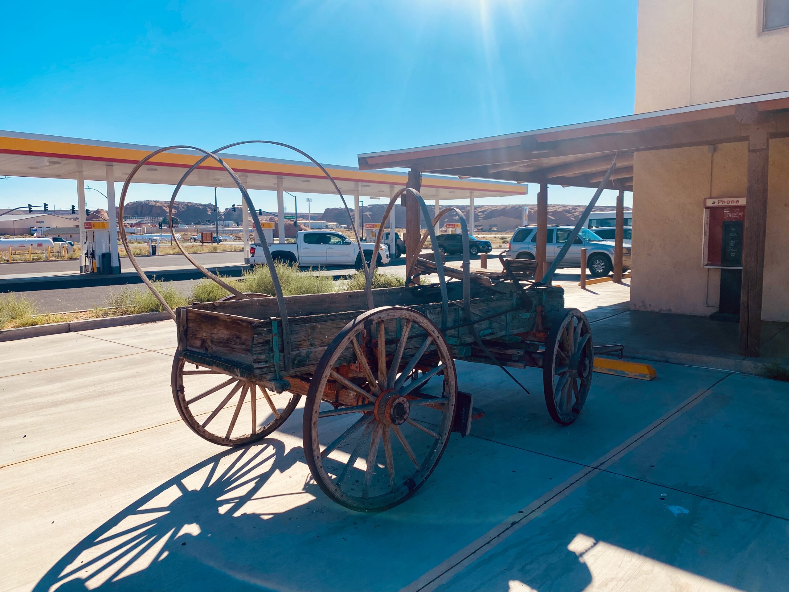 Historic wooden wagon displayed outside Shell at 1501 Coppermine Road in Page Arizona, adding classic Southwest character to the gas station stop