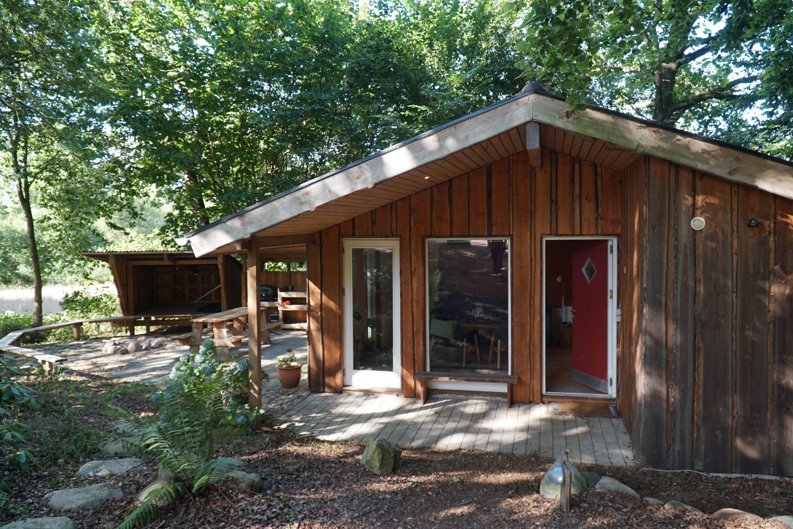 Solevad Cottage in the Forest, wooden tiny house surrounded by trees with outdoor seating and forest setting near Odense, Denmark