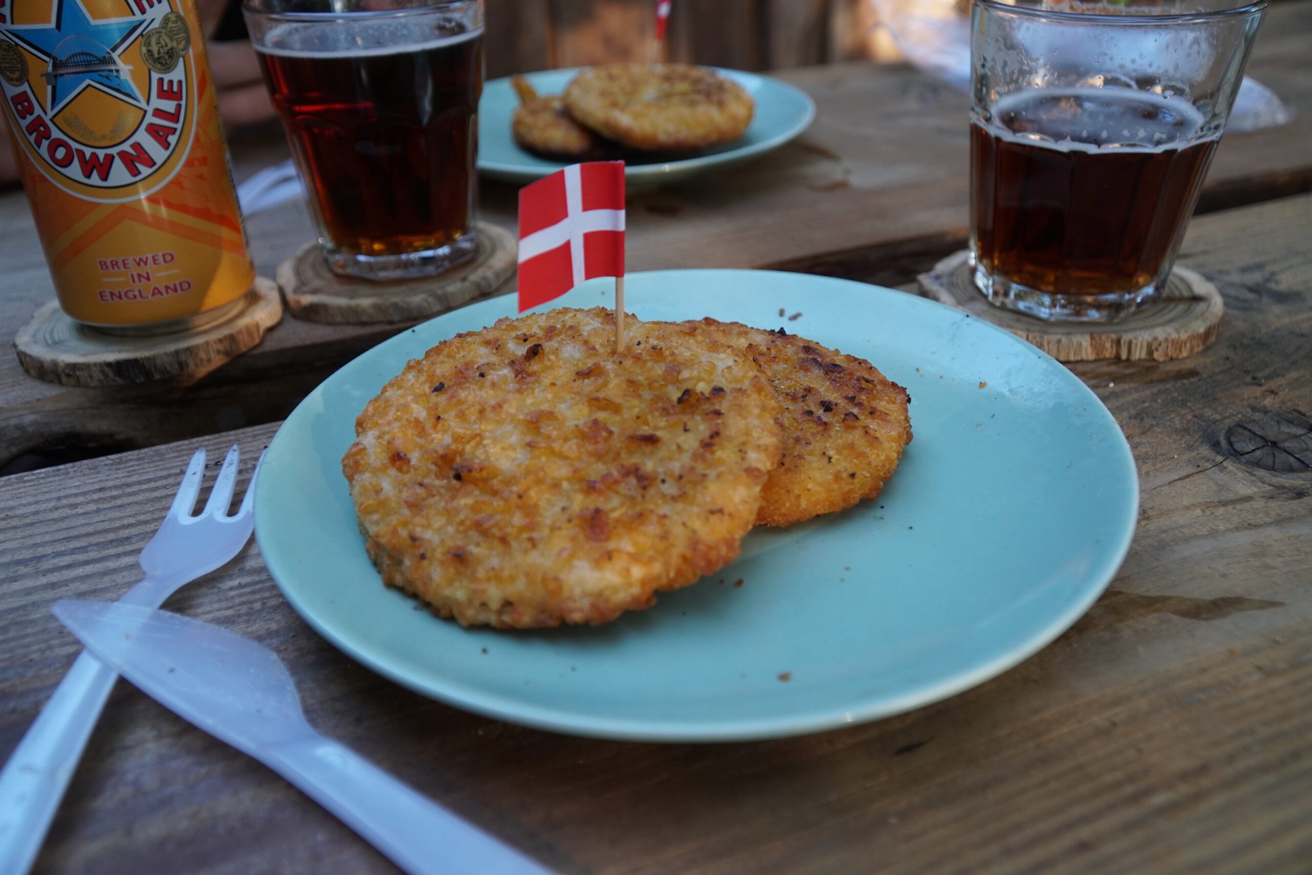 Solevad Cottage in the Forest, Danish potato cakes served on a plate with local brown ale during an outdoor forest dinner