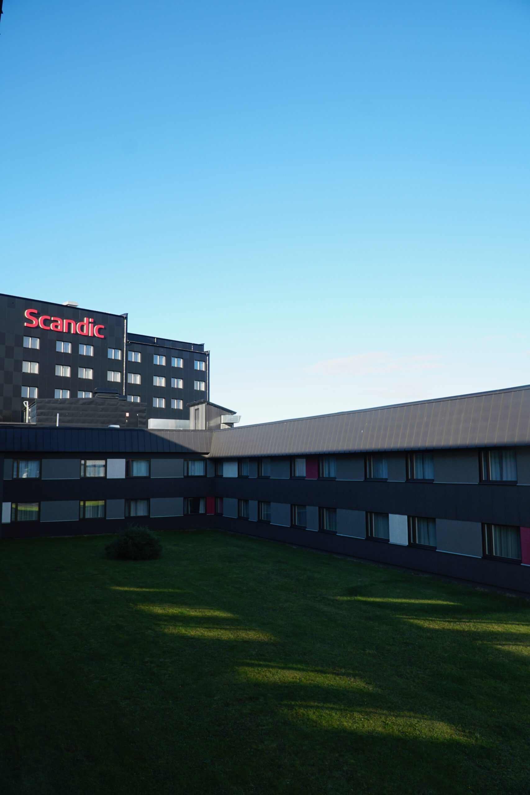 Scandic Luleå Hotel courtyard view from the guest room with modern hotel buildings and clear blue sky in Luleå Sweden