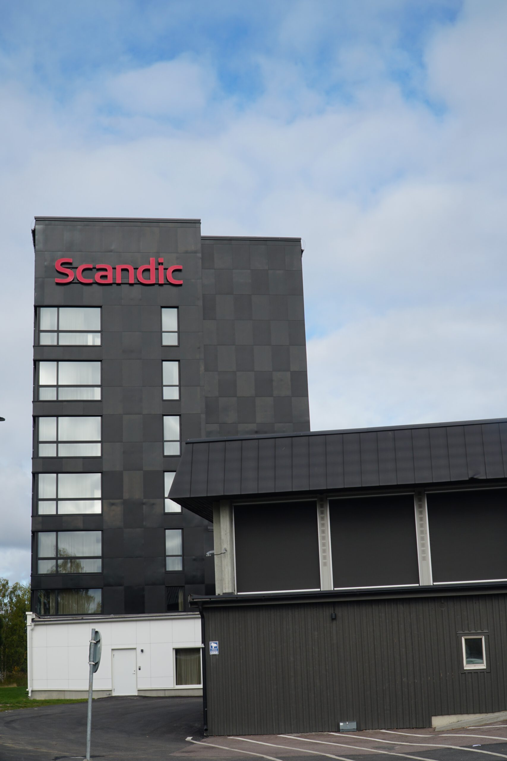 Scandic Luleå Hotel exterior showing the tall hotel tower with Scandic logo in Luleå Sweden under a cloudy sky