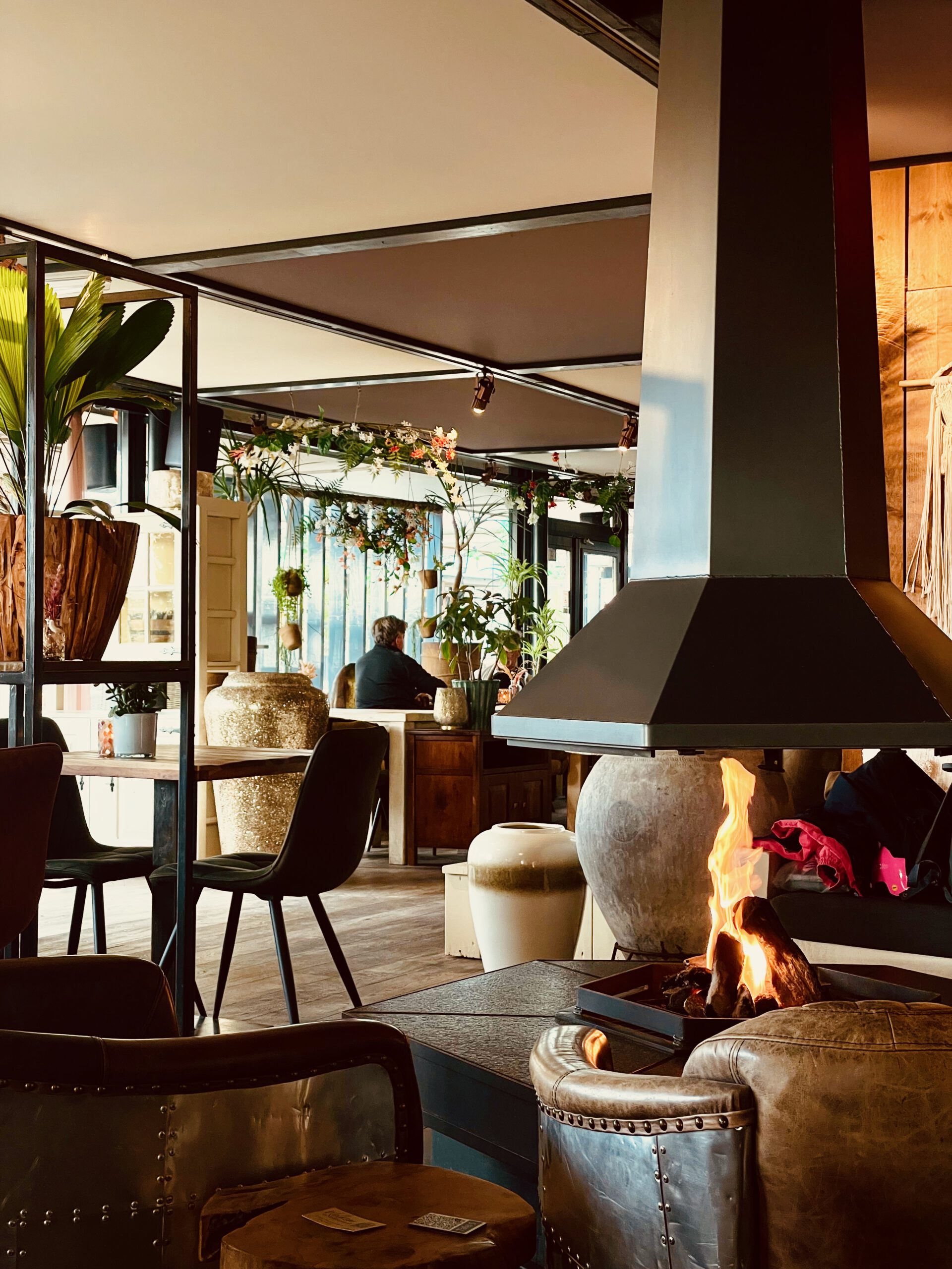 Warm and inviting lounge area at Strandrestaurant Nederzandt Noordwijk featuring an open fireplace, comfortable seating and a stylish beach restaurant atmosphere