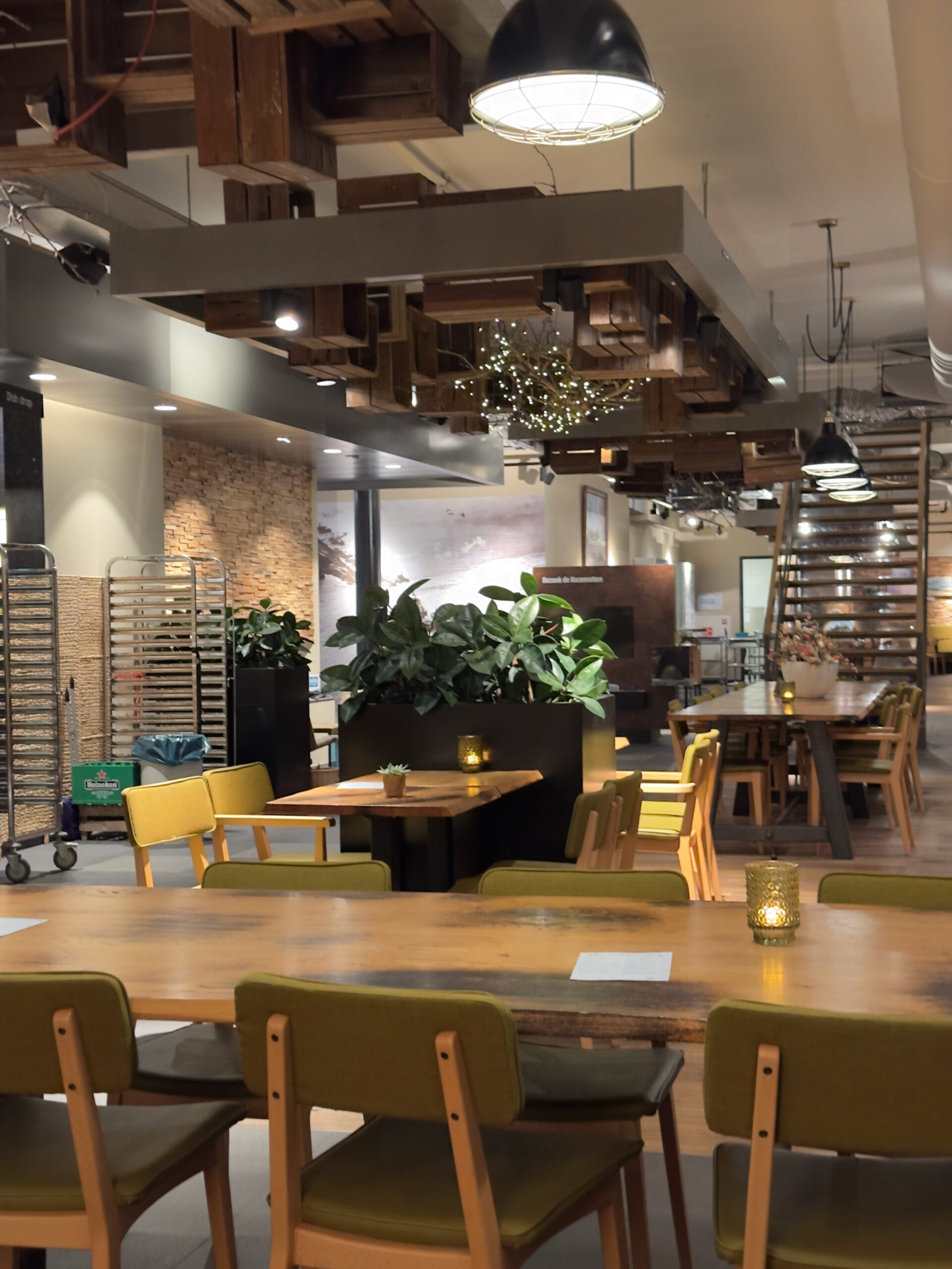 Restaurant Skom interior at the Afsluitdijk Wadden Center featuring a modern, warm dining space with wooden tables and soft lighting