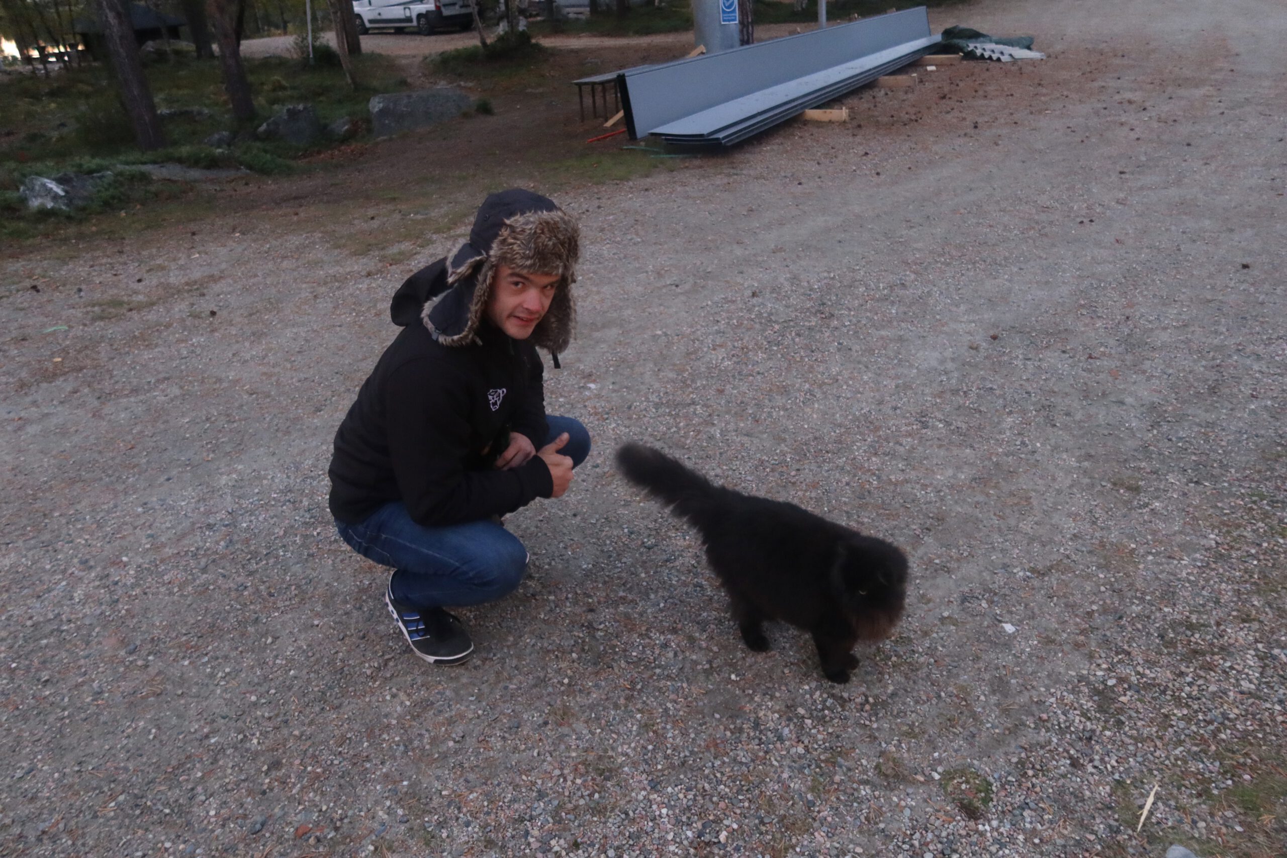 Peter Smit at Hetan Kota in Enontekiö, Finland, checking out while spotting a curious black cat on the grounds, surrounded by tranquility, gravel paths, and Lapland wilderness.