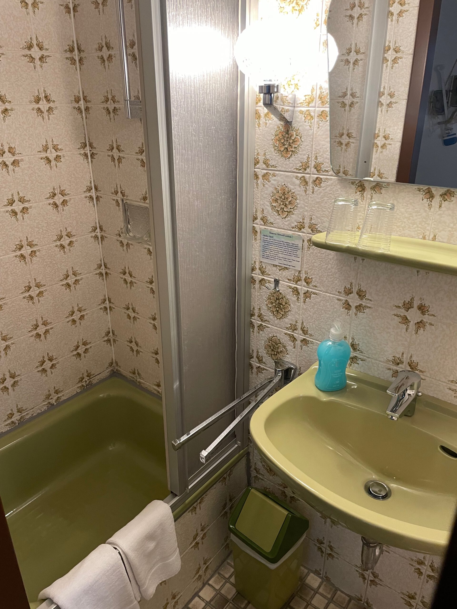 Hotel Aal-Kate Wuppertal vintage bathroom with classic tiles, compact shower, sink and well maintained retro interior in Wuppertal Germany