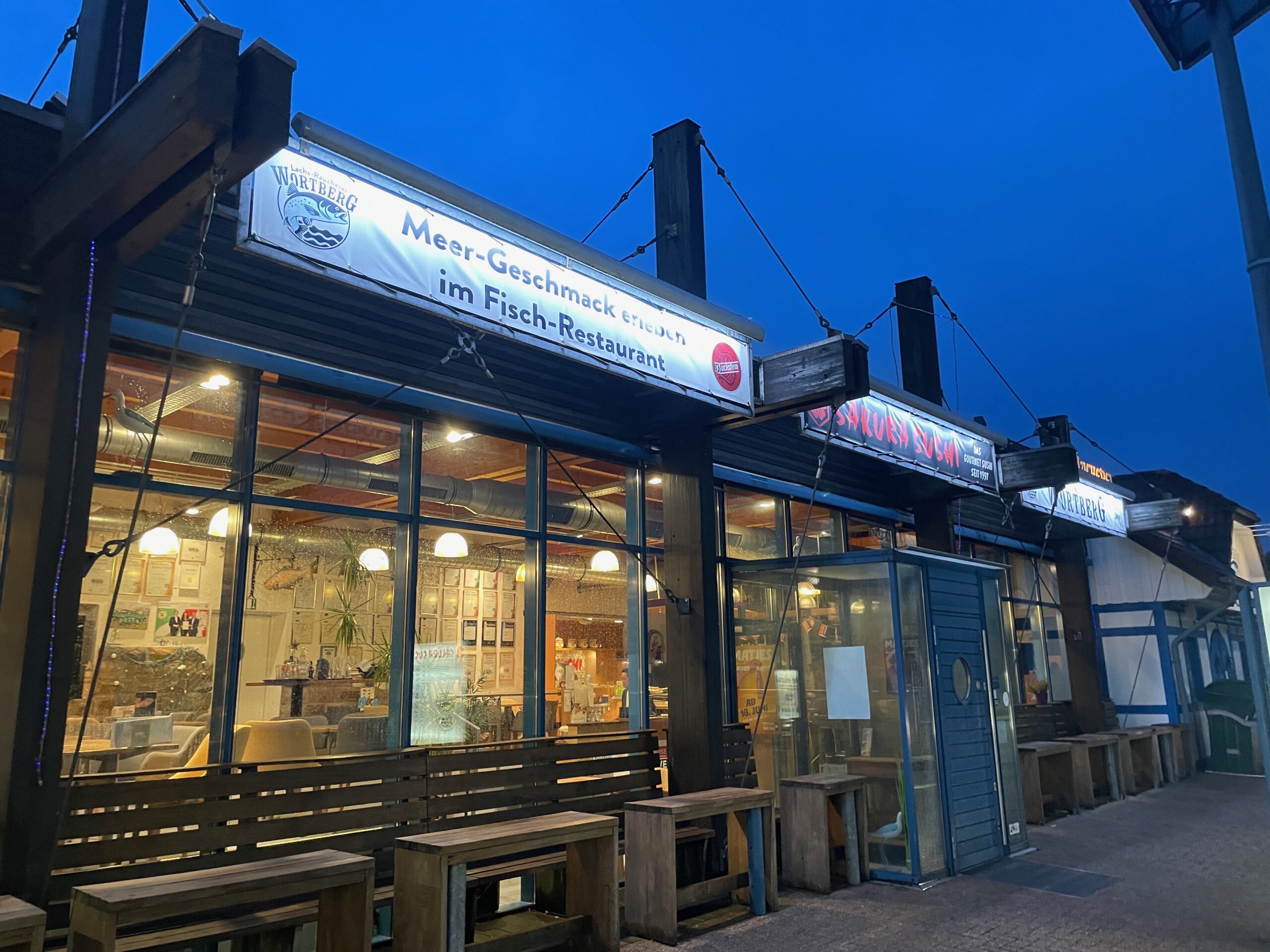 Lachs Räucherei Wortberg Sakura Sushi Wuppertal restaurant exterior with illuminated signage and seafood restaurant entrance in the evening