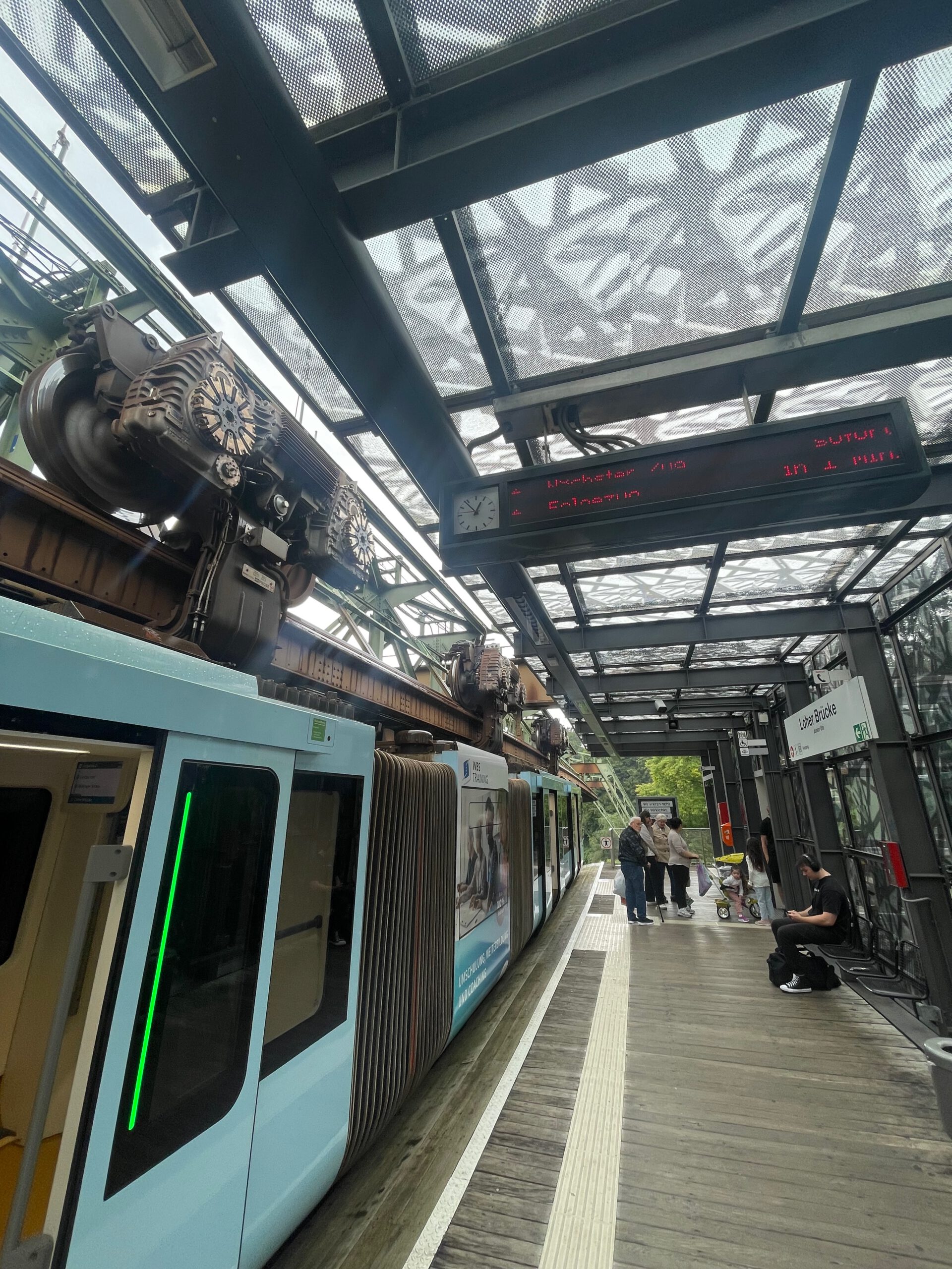 Schwebebahn Wuppertal platform with suspended train arriving at Loher Brücke station above the city