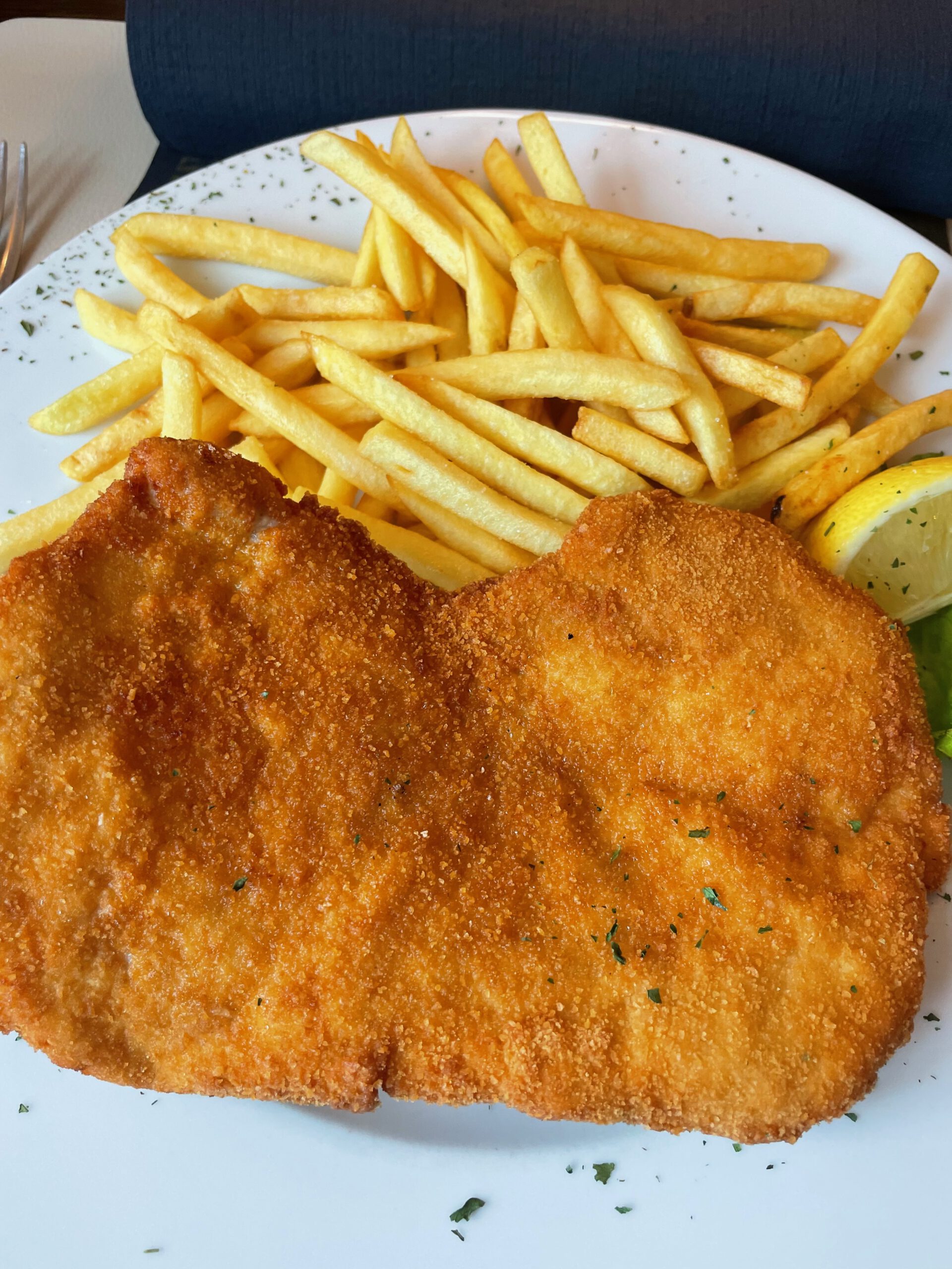 Wiener schnitzel with fries served at Westfalenkrug Wuppertal restaurant, classic German comfort food