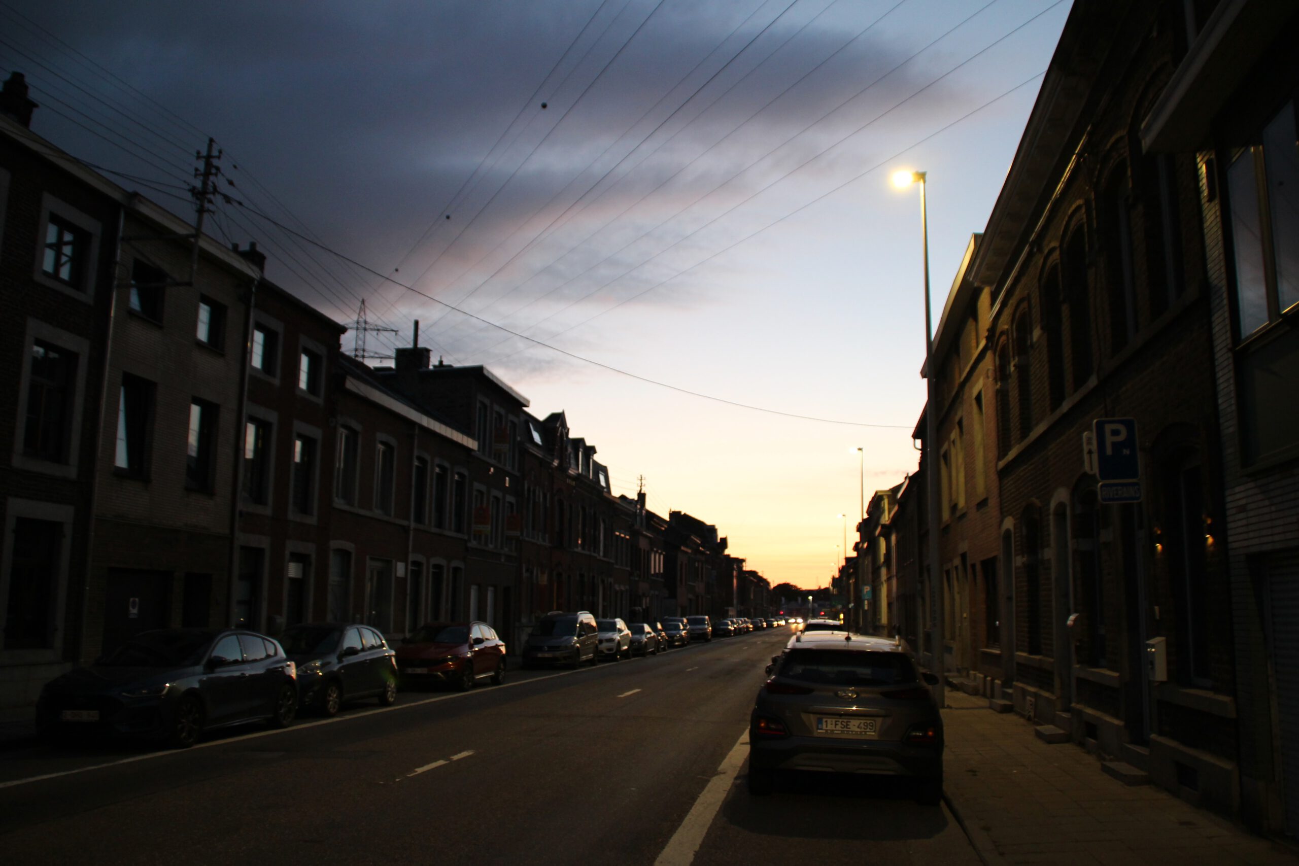 Le cocon de Chênée Liège surroundings, evening view of the busy main street in Chênée with parked cars and residential buildings