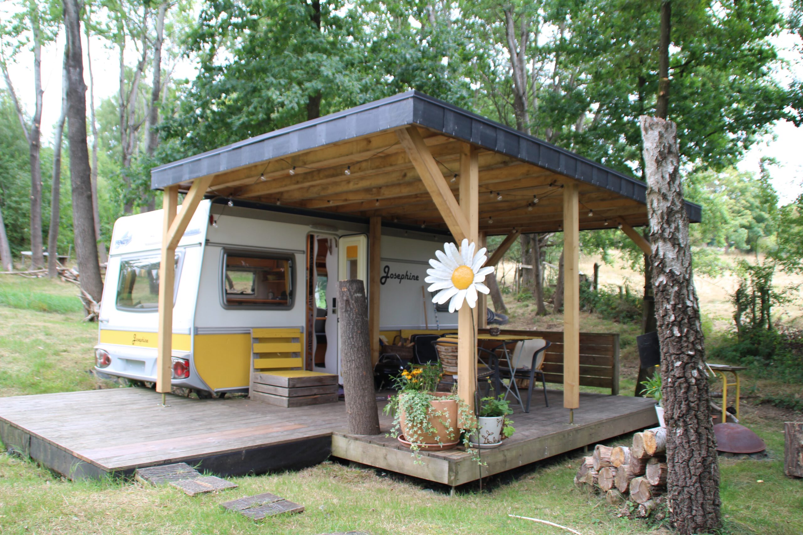 Josephine Caravan Aywaille renovated vintage caravan with wooden terrace, seating area, and private forest surroundings in Belgium