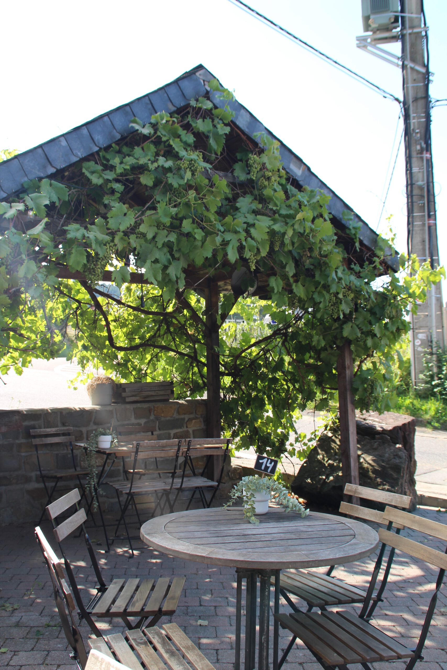 Le Coffee Ride garden terrace in the Belgian Ardennes, peaceful outdoor seating area surrounded by greenery in Stavelot