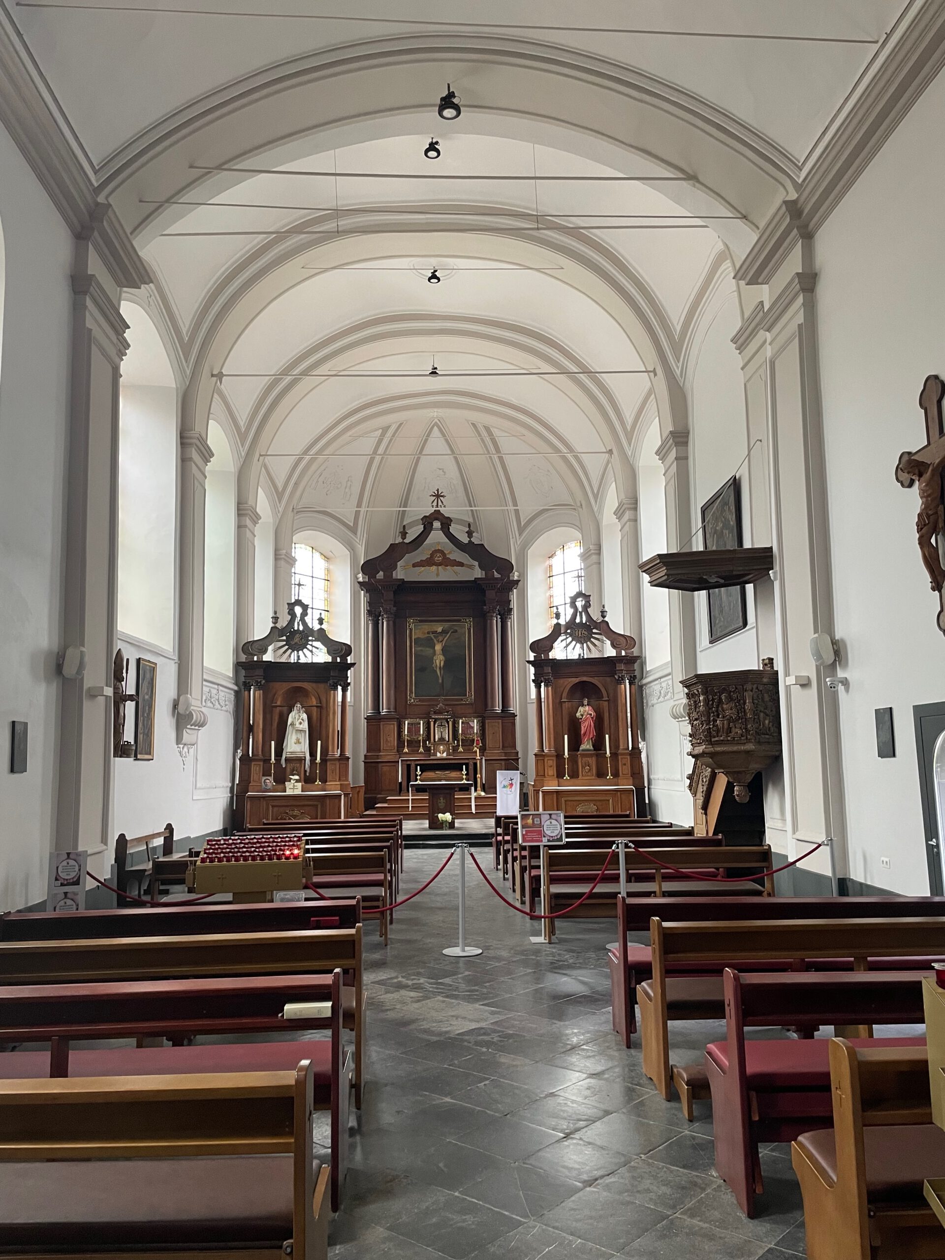 Durbuy travel experience inside the Église Saint Nicolas showing the peaceful church interior with wooden altars and arched ceiling