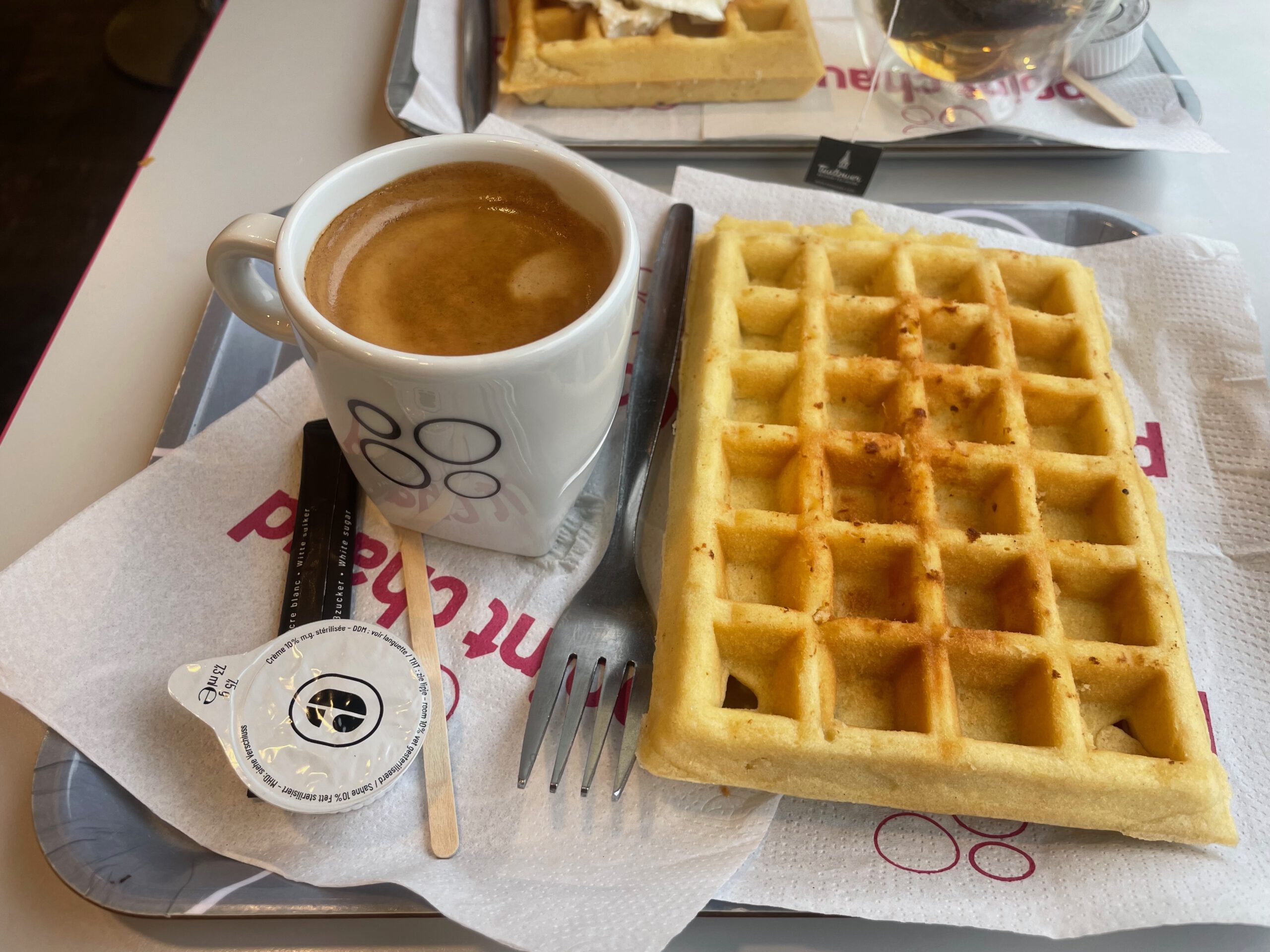 Boulangerie Aywaille centre Point Chaud waffle with coffee on tray, simple breakfast served inside the bakery