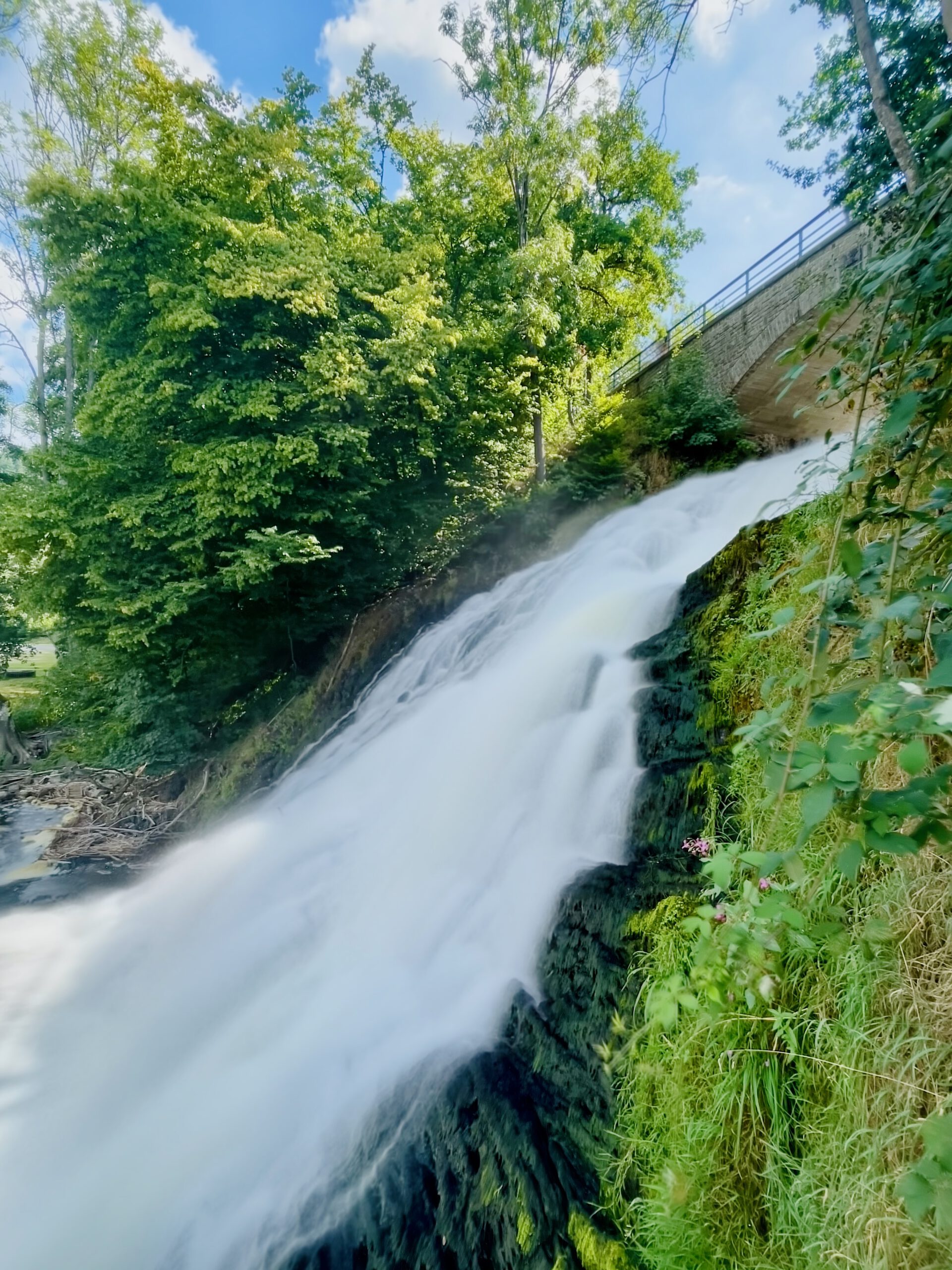 Watervallen van Coo waterfall cascading over moss covered rocks in the Belgian Ardennes, close up view of flowing water surrounded by green forest near Coo and Stavelot