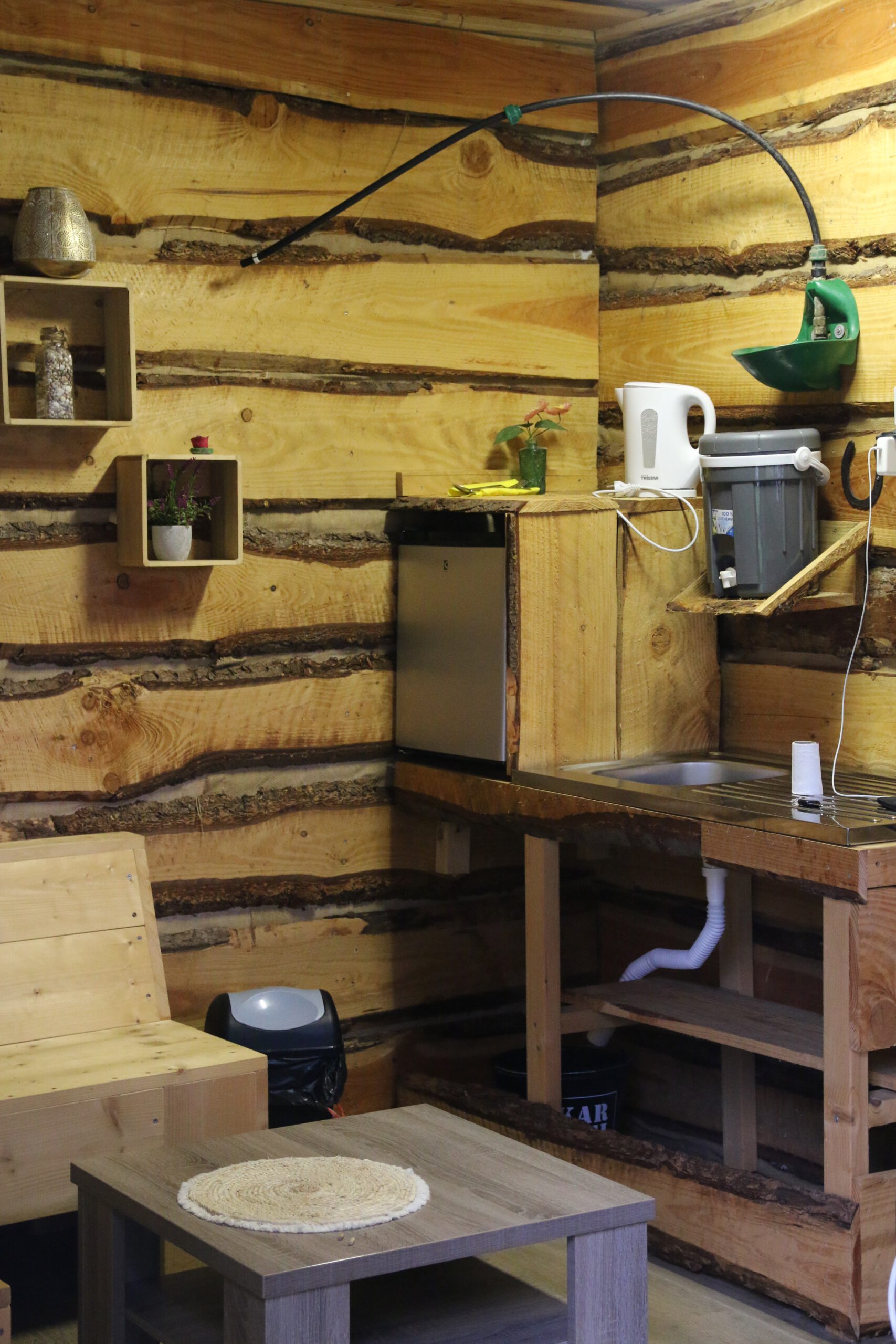 Back To Basic Zwaanshoek interior with wooden walls, simple seating area and basic kitchen setup