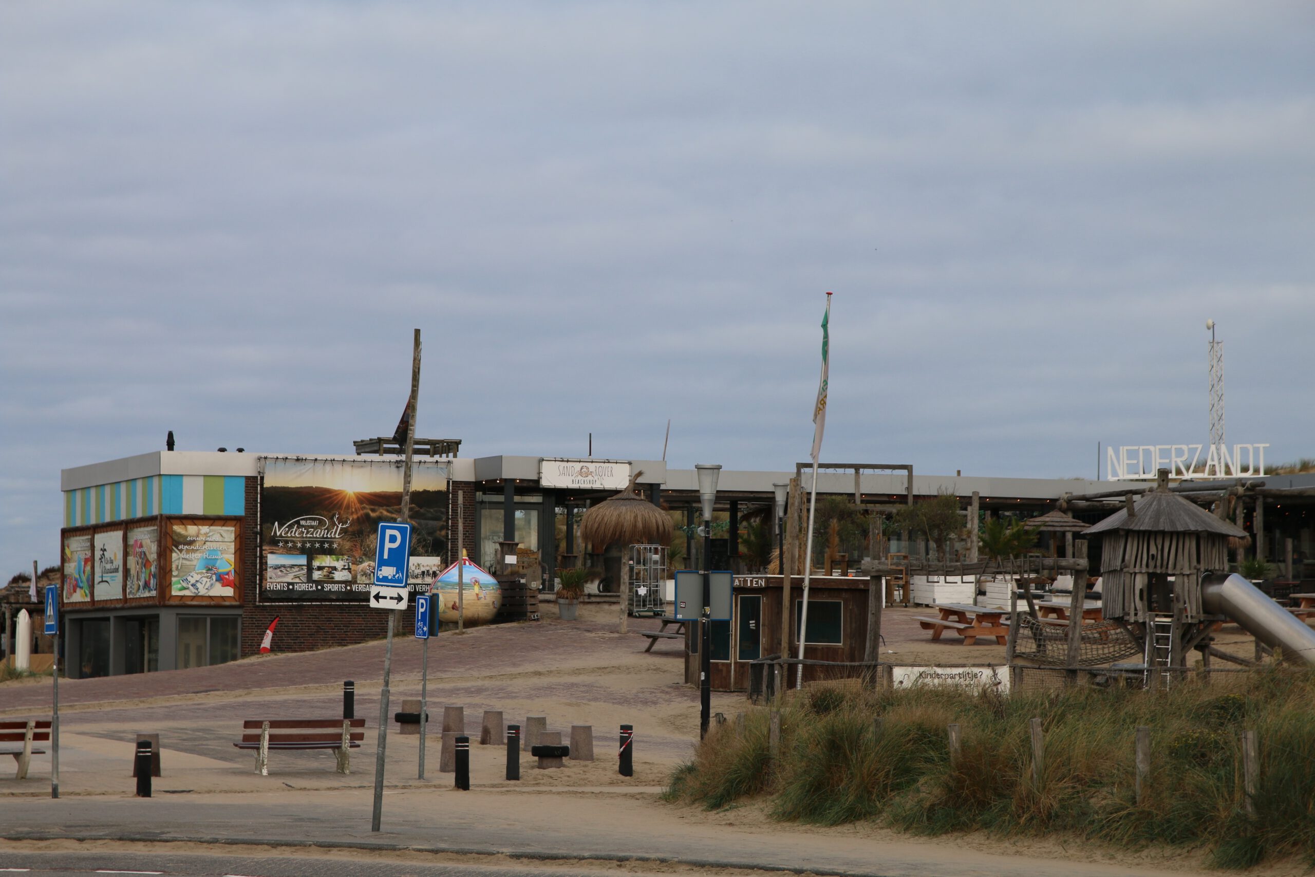 Strandrestaurant Nederzandt Noordwijk seen from the entrance near the dunes, showing the beach restaurant, playground, and sustainable coastal setting at Langevelderslag