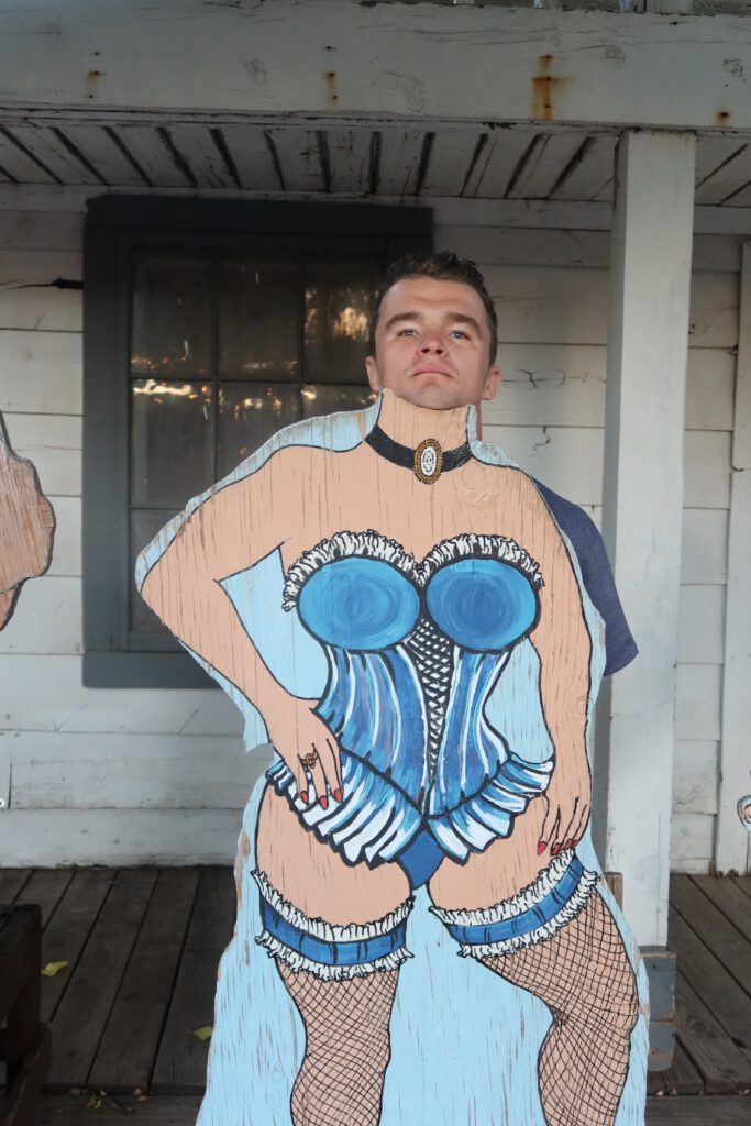 Guest posing behind a playful Old West themed cutout at Iron Horse Kanab Utah, showcasing the restaurant’s humorous western decor and fun photo spots.
