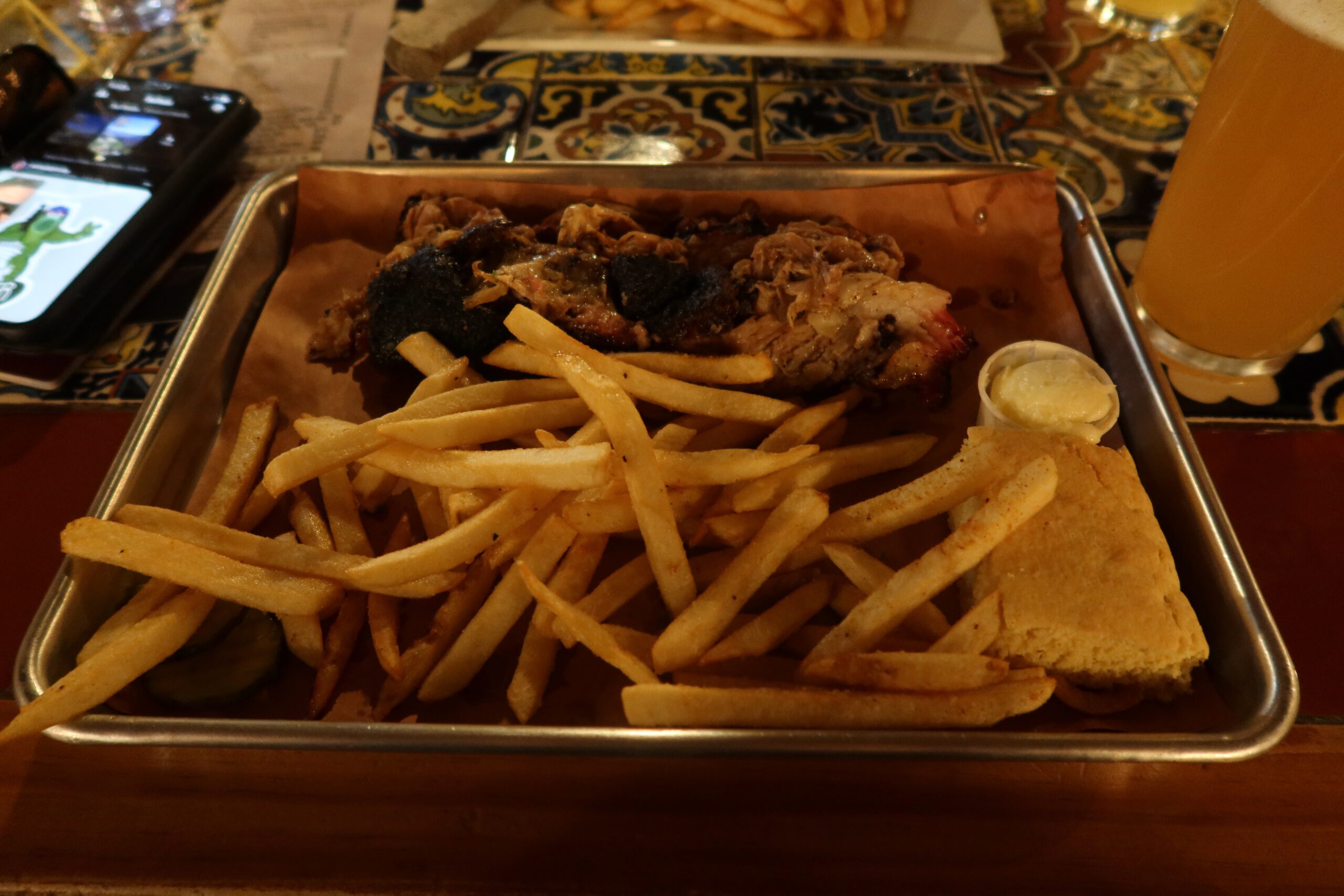 Smoked pulled meat platter at Iron Horse Kanab Utah served with crispy fries, rustic bread, and dipping sauce, showcasing hearty western comfort food.
