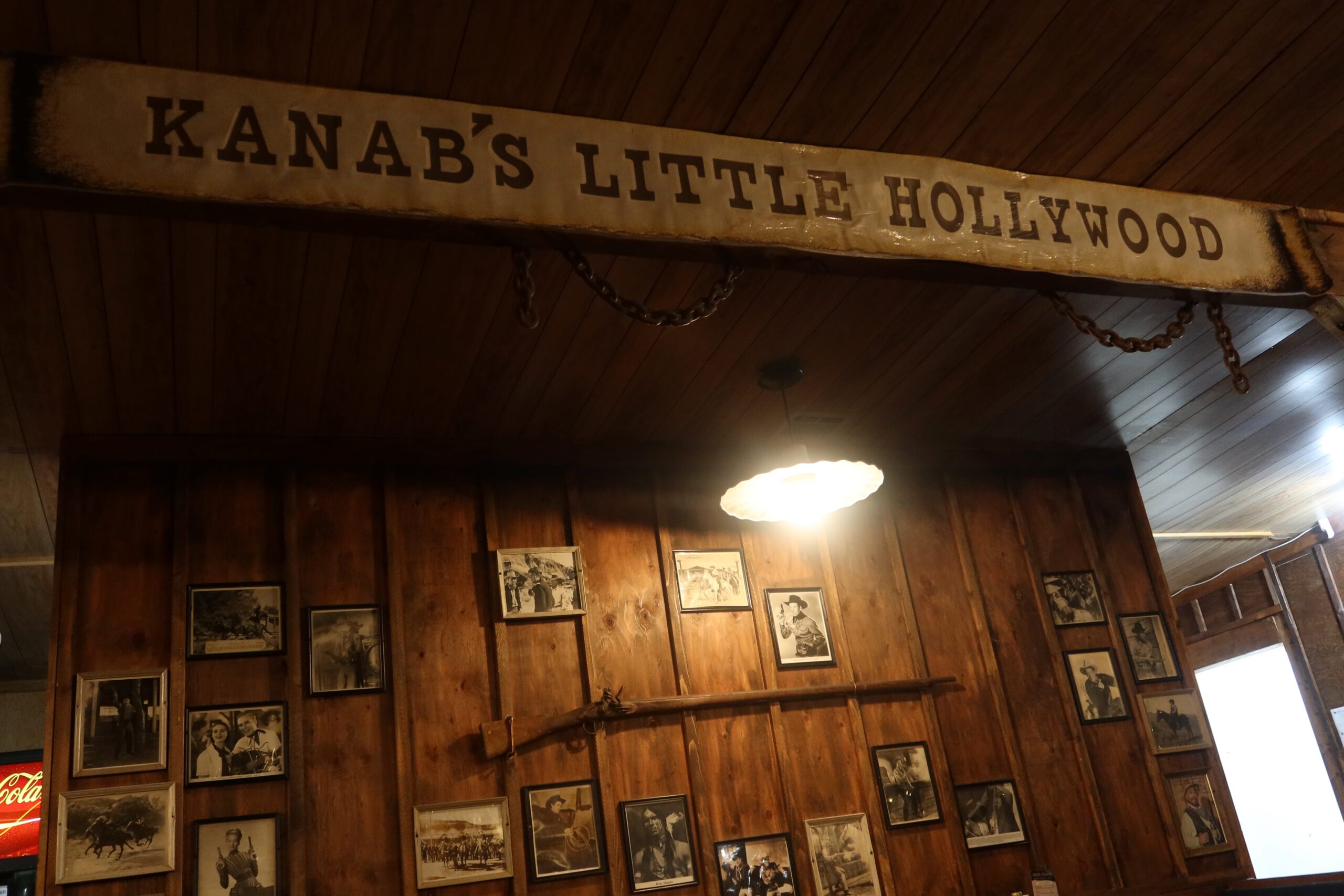 Interior wall at Iron Horse Kanab Utah featuring vintage western photos, rustic wood decor, and a sign reading Kanab’s Little Hollywood, reflecting the Old West atmosphere of the restaurant.
