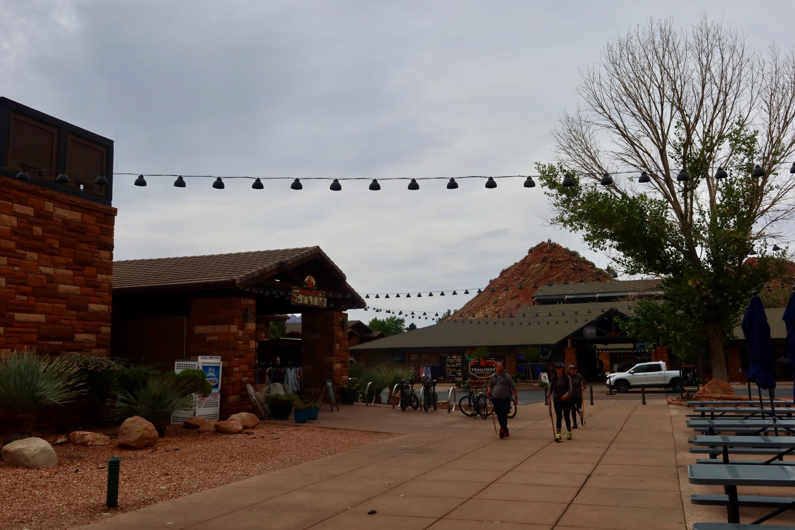 Springdale town center near Zion National Park with sandstone buildings, outdoor shops, and visitors walking beneath string lights