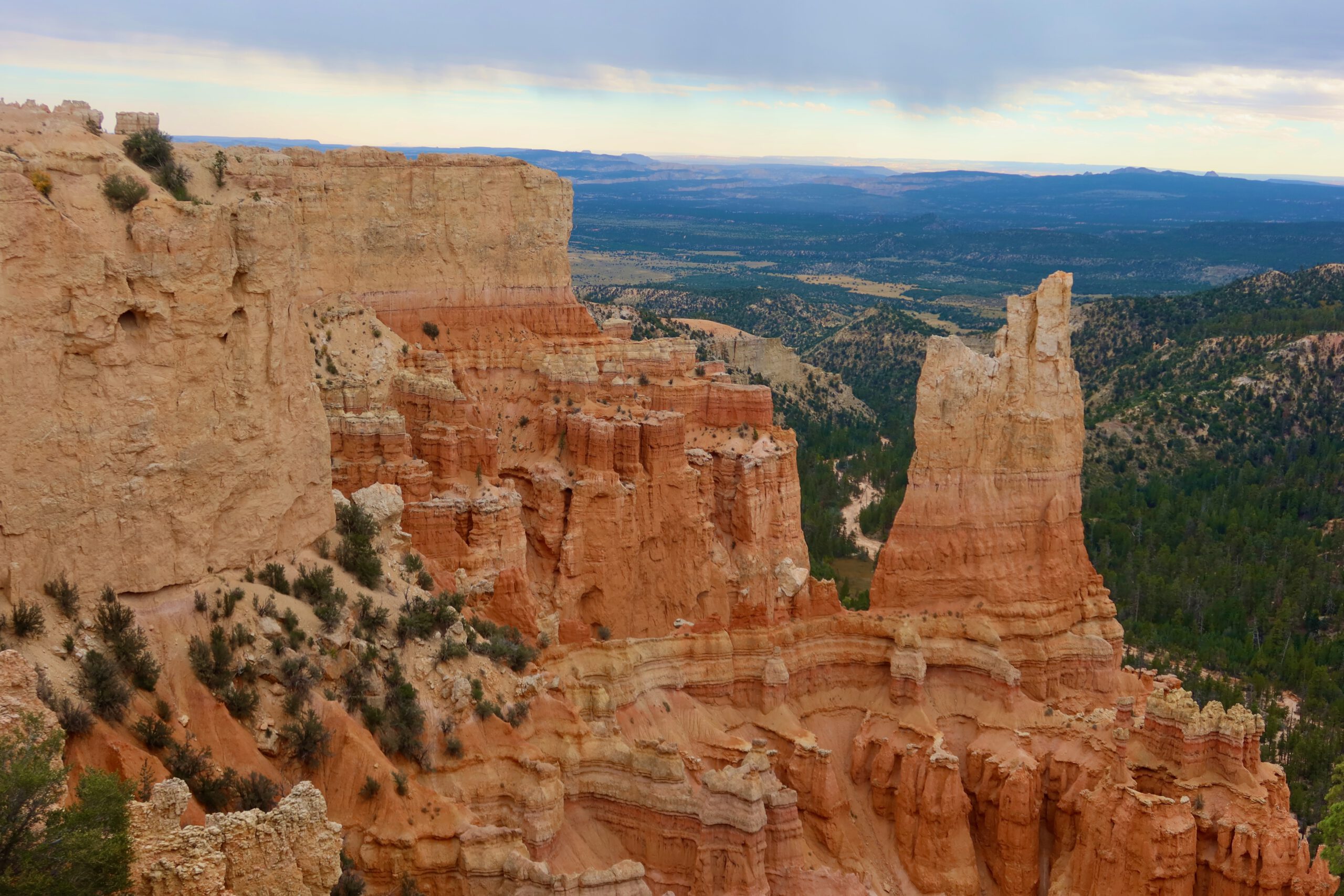 Iconic hoodoo formations and towering sandstone cliffs in Bryce Canyon National Park, showcasing Utah’s dramatic orange and red rock landscape