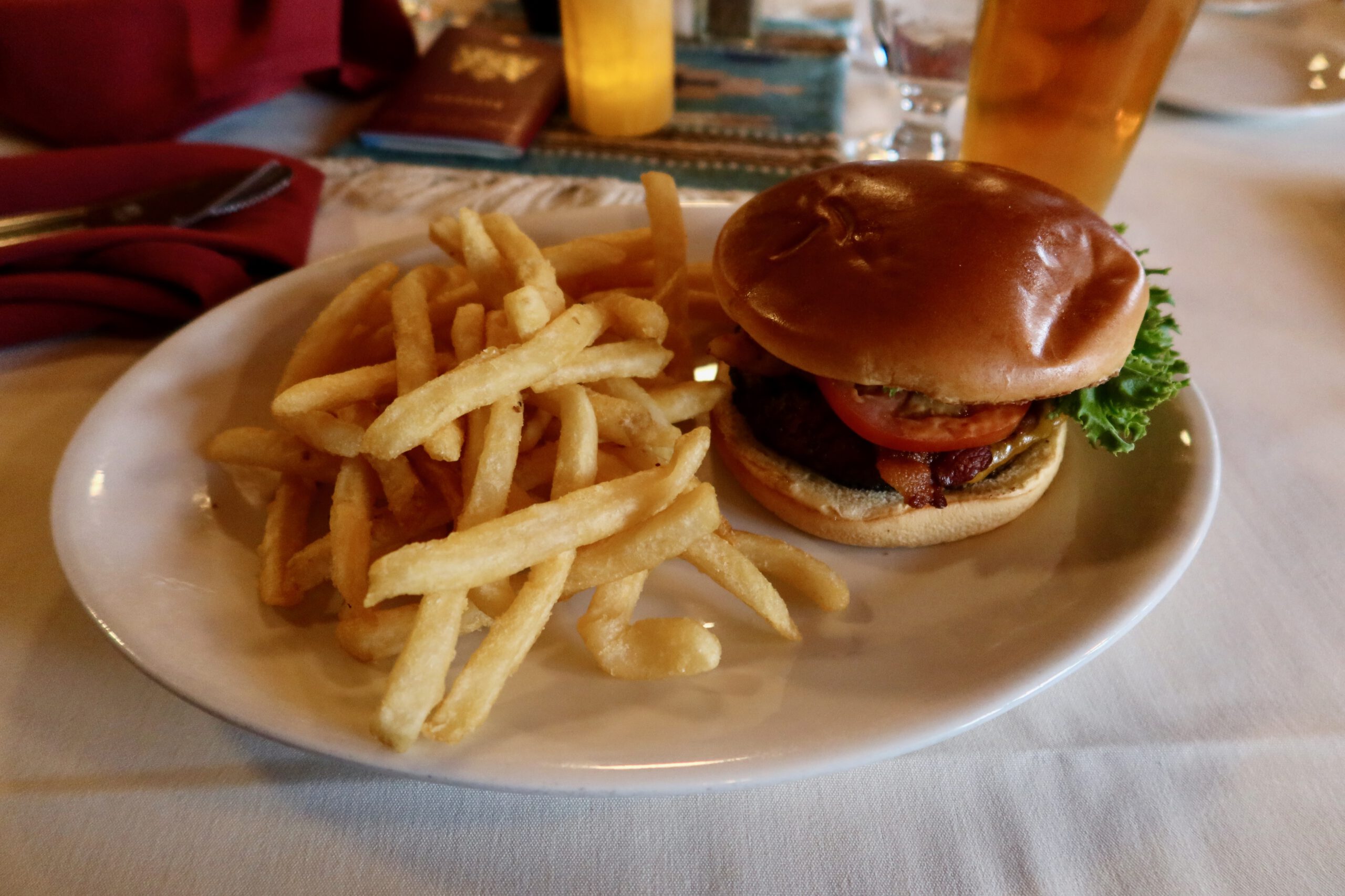 Burger and fries at The Lodge at Bryce Canyon Restaurant inside Bryce Canyon National Park, a freshly served beef burger with lettuce, tomato, bacon, and crispy fries on a white plate