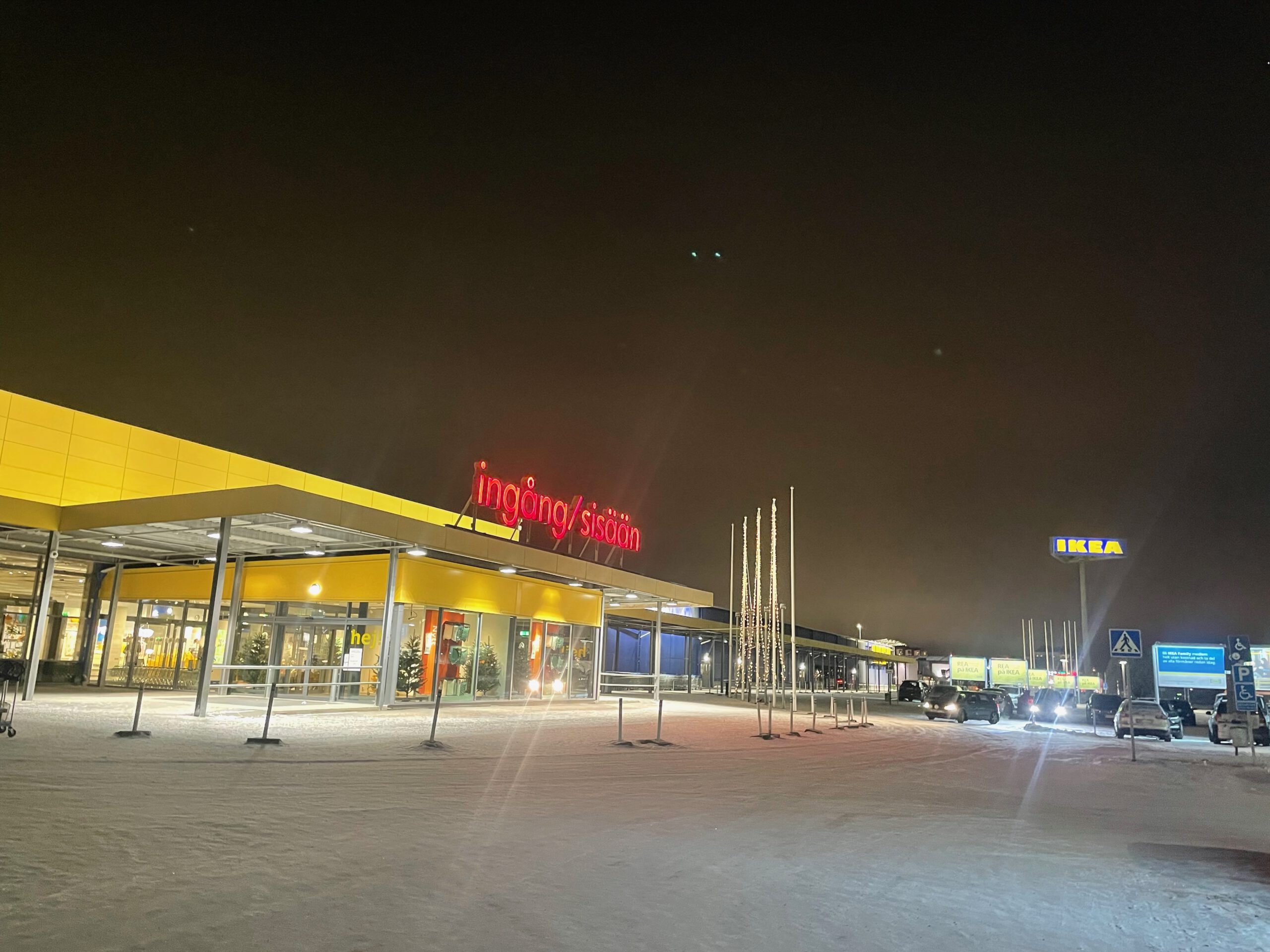 IKEA Haparanda Restaurant and Store entrance at night in winter, illuminated yellow facade, snowy parking area and entrance signage at the northernmost IKEA in the world